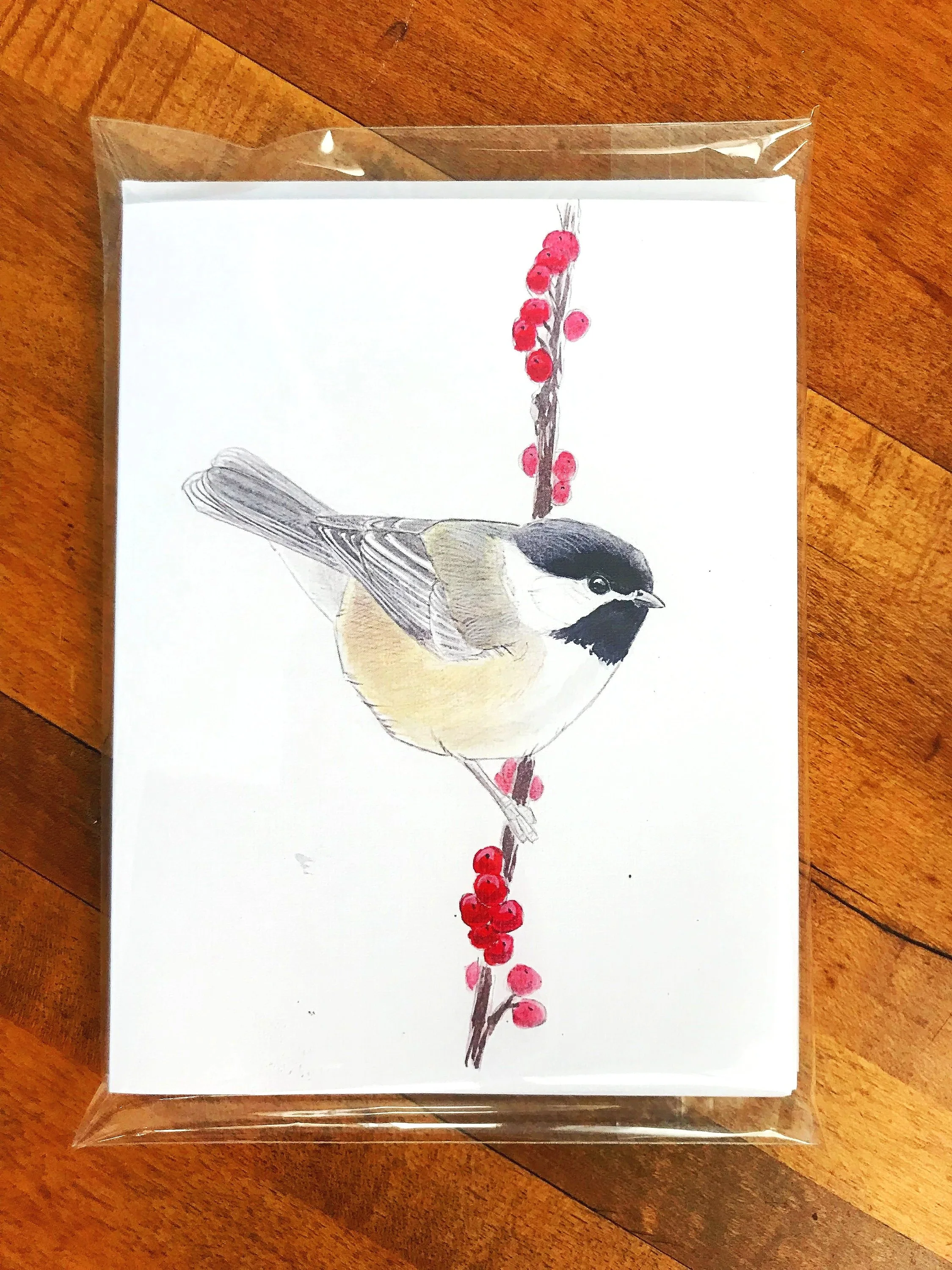 Watercolor illustration of a chickadee perched on a thin branch with red berries, set against a white background.