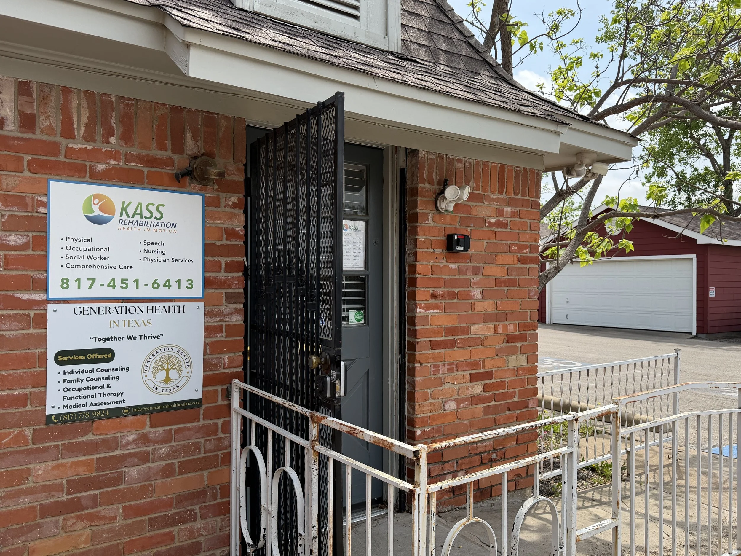 The exterior of a brick building housing KASS Rehabilitation and Generation Health in Texas, with a sign listing services like physical, occupational, and speech therapy, and a white metal railing outside the door.