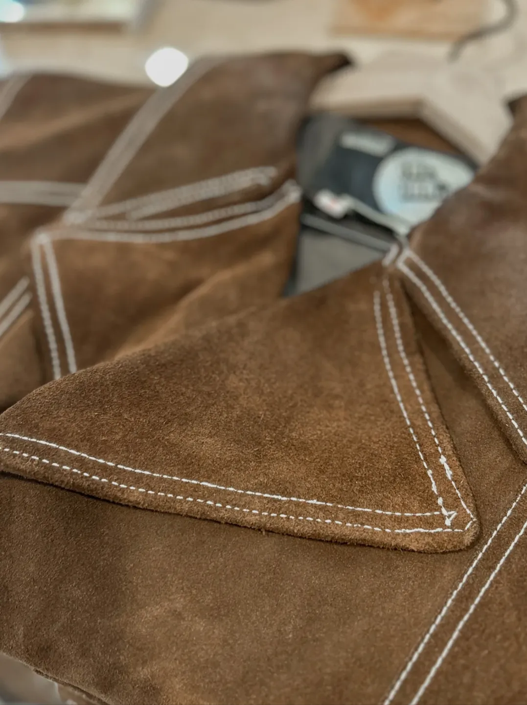 Detail of a vintage brown suede shirt with contrasting Western stitching at ORTENSE.