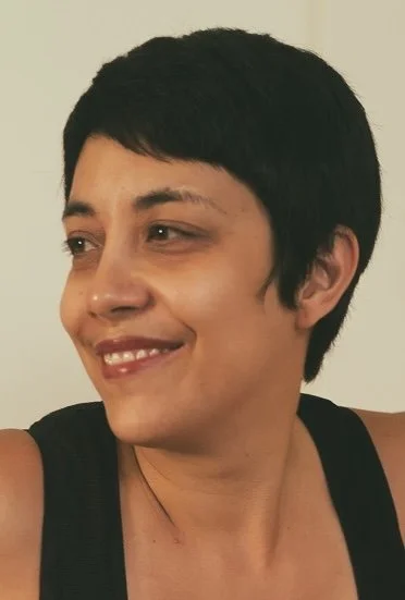 Person smiling, short dark hair, wearing black top