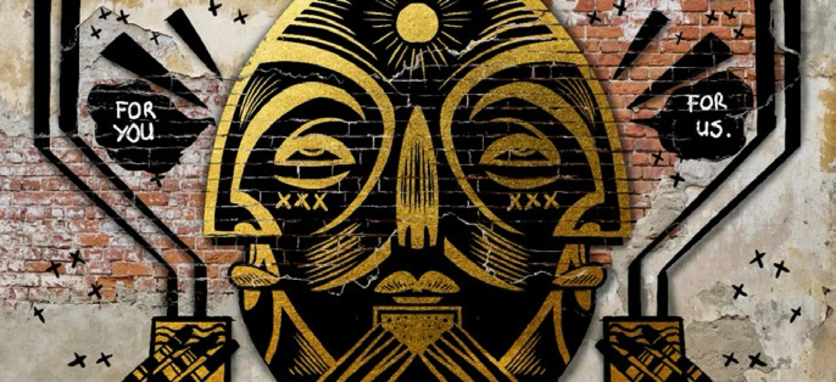 Graffiti art of a stylized human skull with abstract features painted on a brick wall, with the words 'For you' on the left and 'For us' on the right inside black speech bubbles.