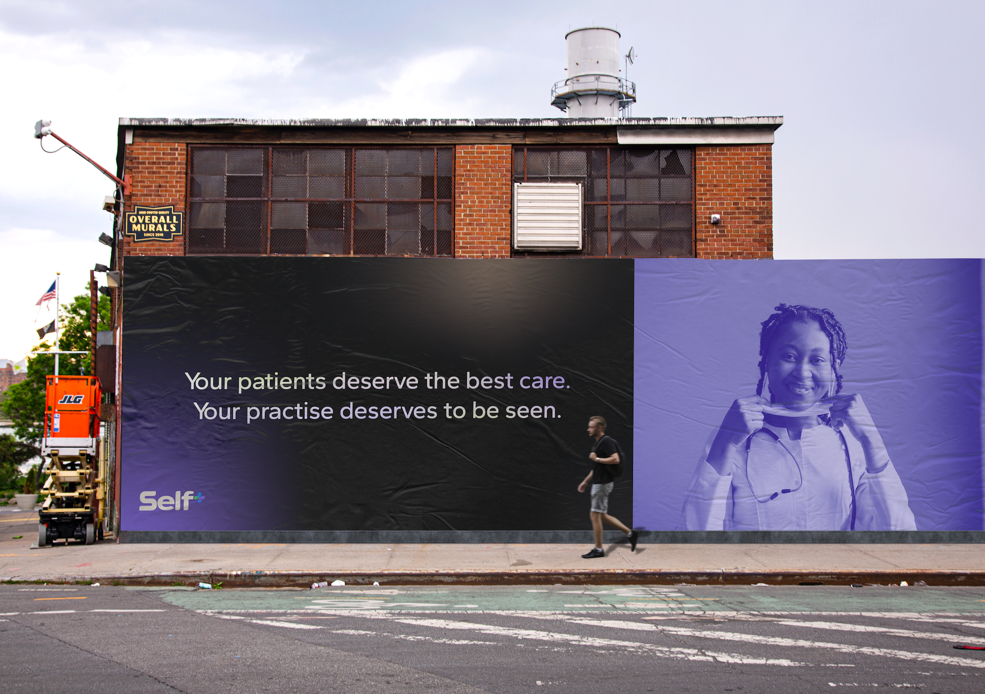 Large billboard on side of brick building with a message about healthcare and patient care, featuring a woman in medical attire holding a stethoscope, and a person jogging past on the sidewalk.