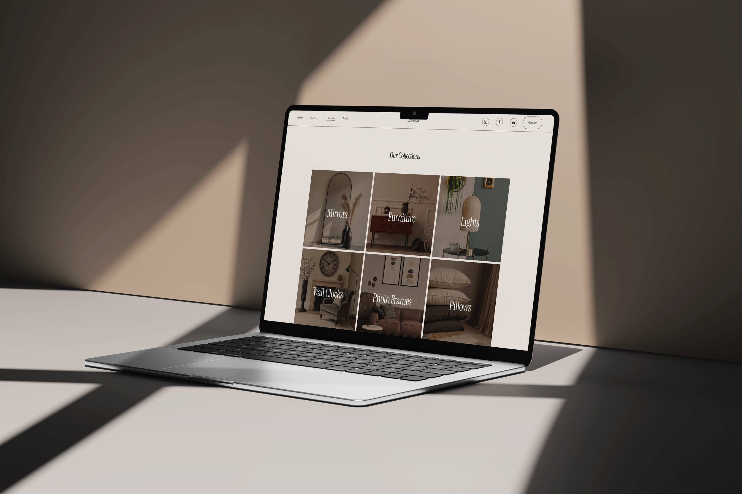 Open laptop on a table displaying an interior decor website with categories such as Mirrors, Furniture, Lights, Wall Clocks, Photo Frames, and Pillows.