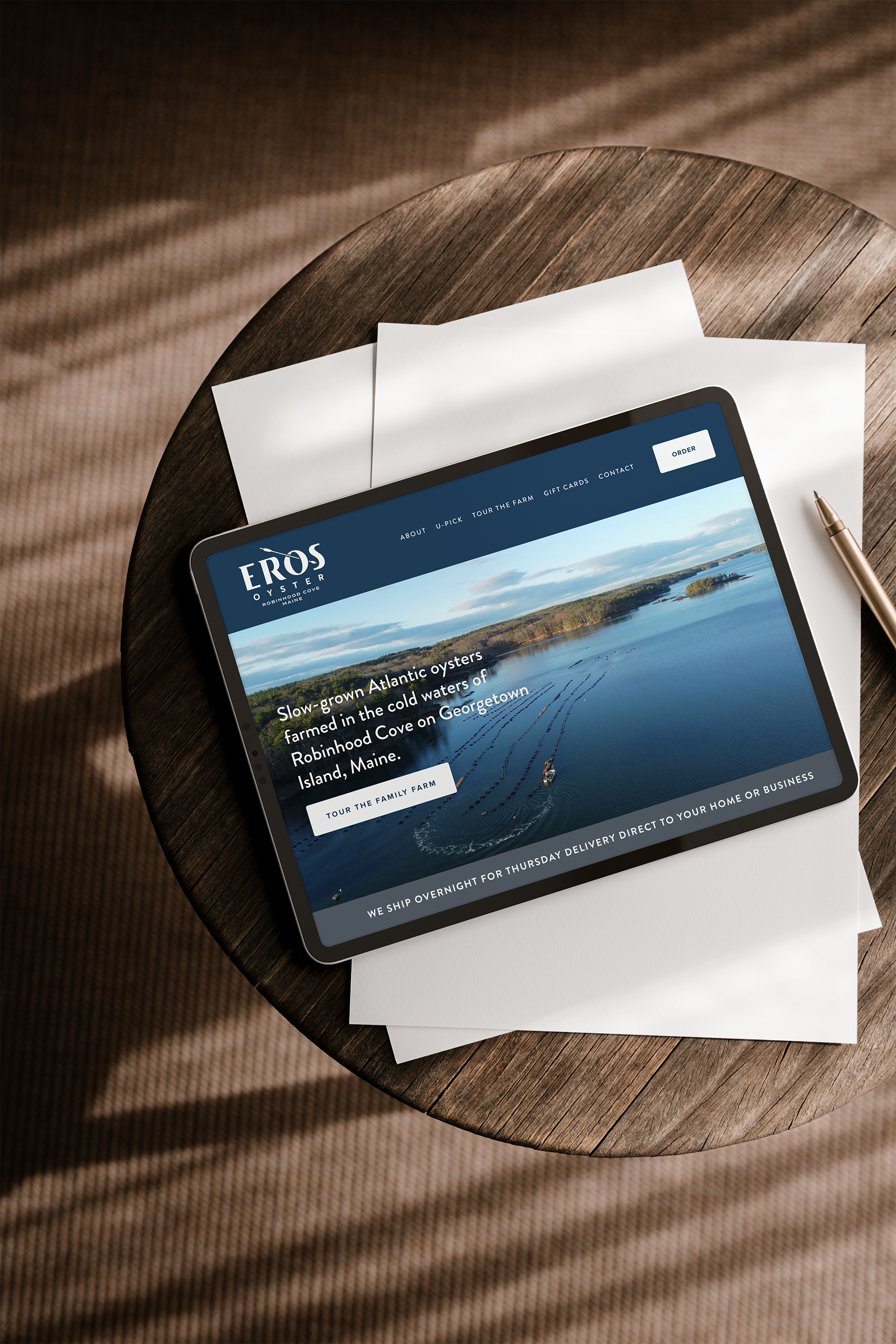 A tablet on a wooden table displaying a website for Eros Oysters that was design by Nana Potenza.