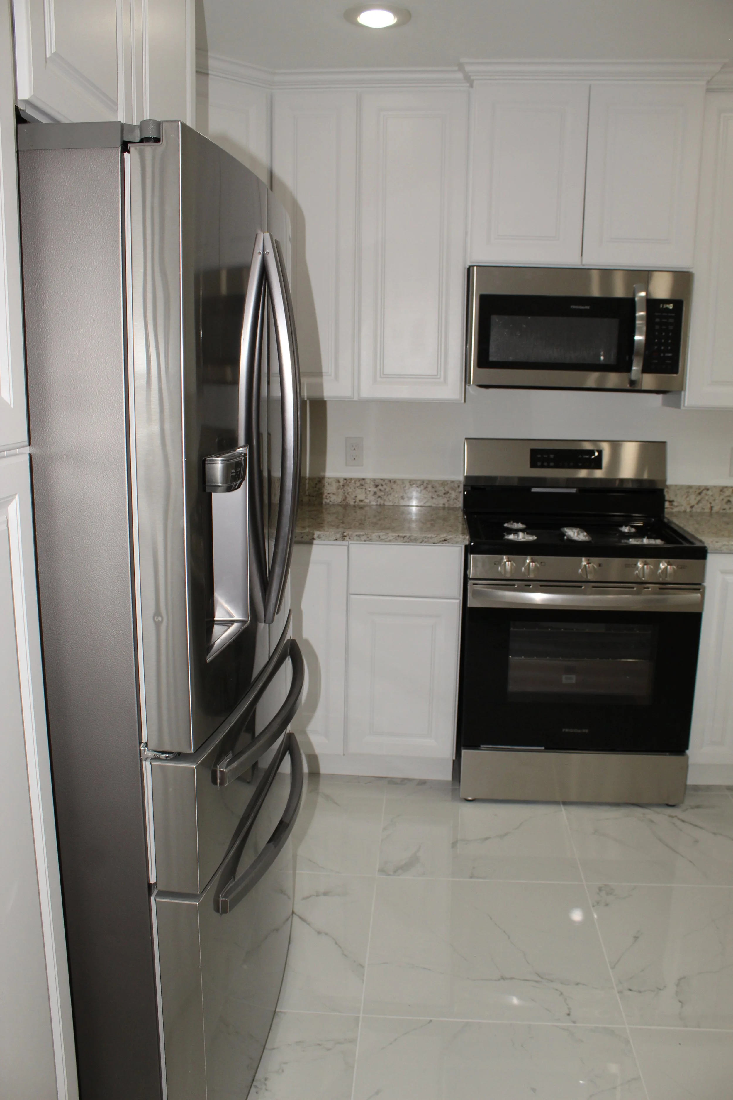 newly remodeled minimalistic kitchen cabinets and countertops with stove and fridge