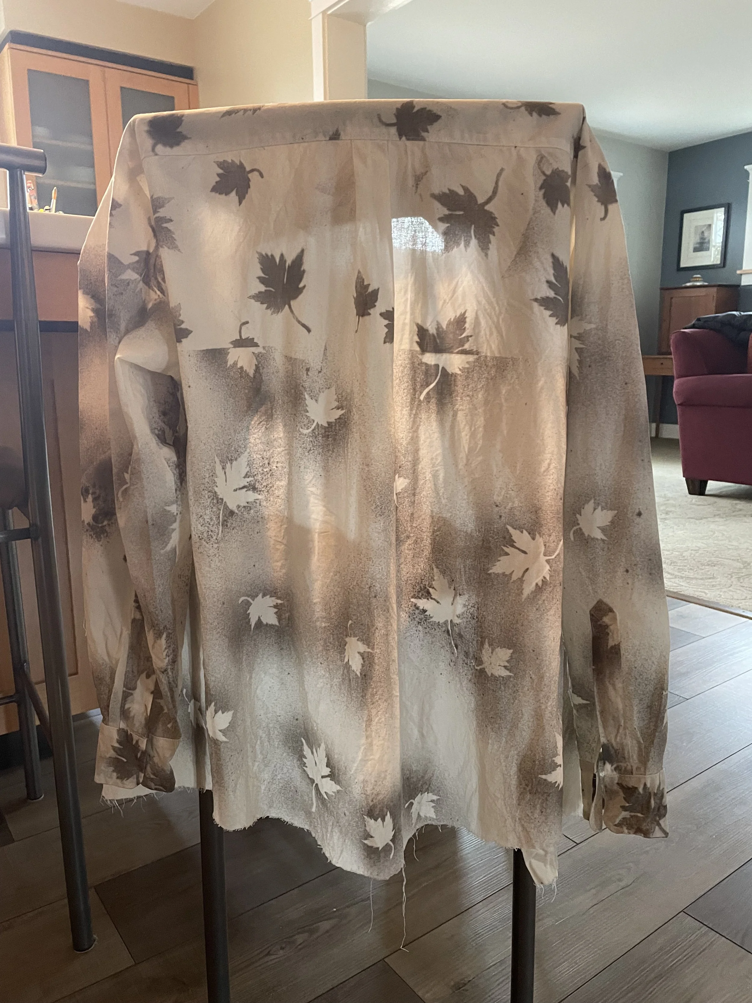 Naturally dyed button up hanging on a kitchen chair with oak leaf patterns. Naturally dyed button-up. Naturally dyed button-up. Naturally dyed button-up. Naturally dyed button-up. Naturally dyed button-up. Naturally dyed button-up. Naturally dyed