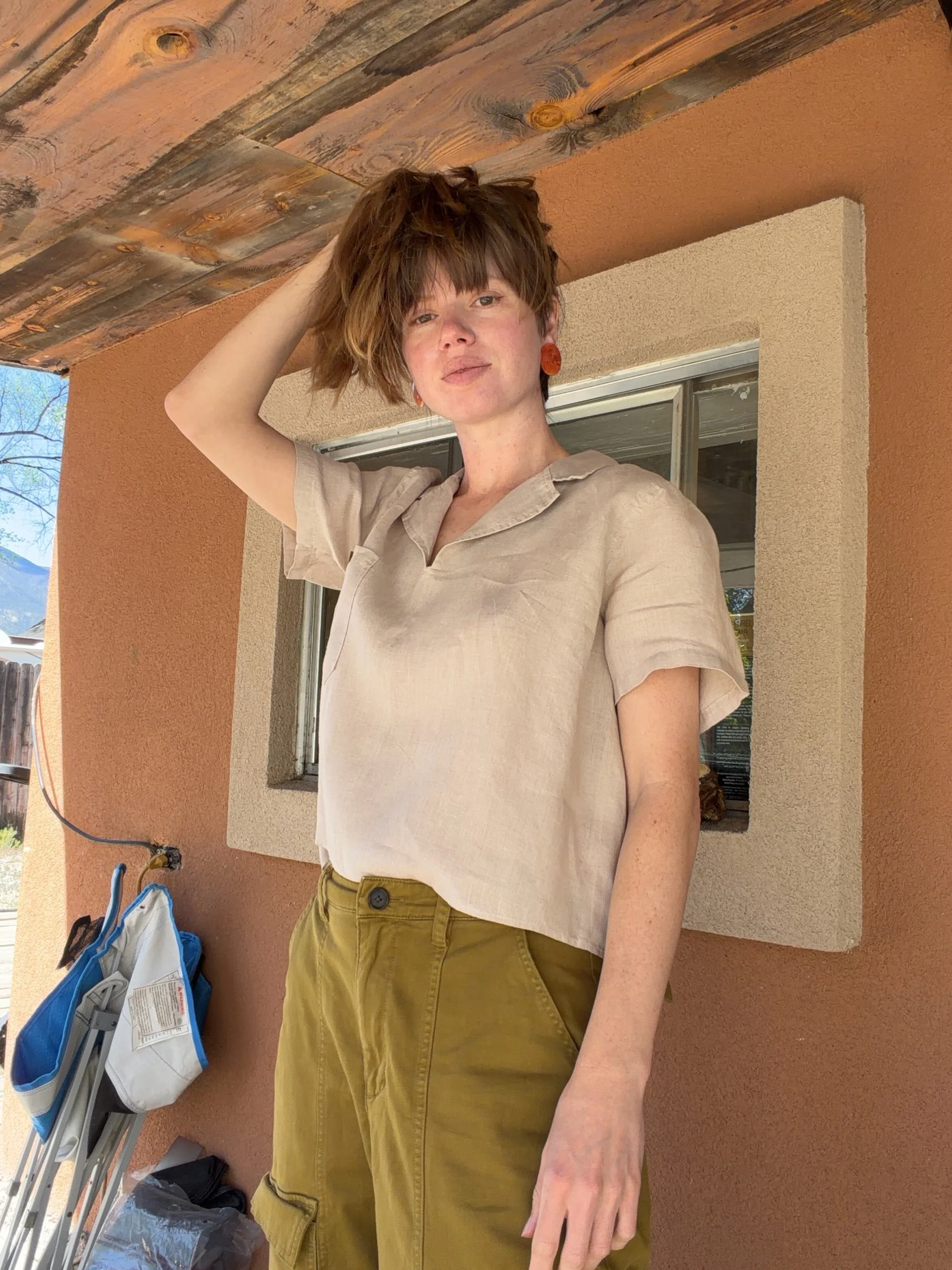 Woman holding her hair up modeling the walnut v-notch crop shirt