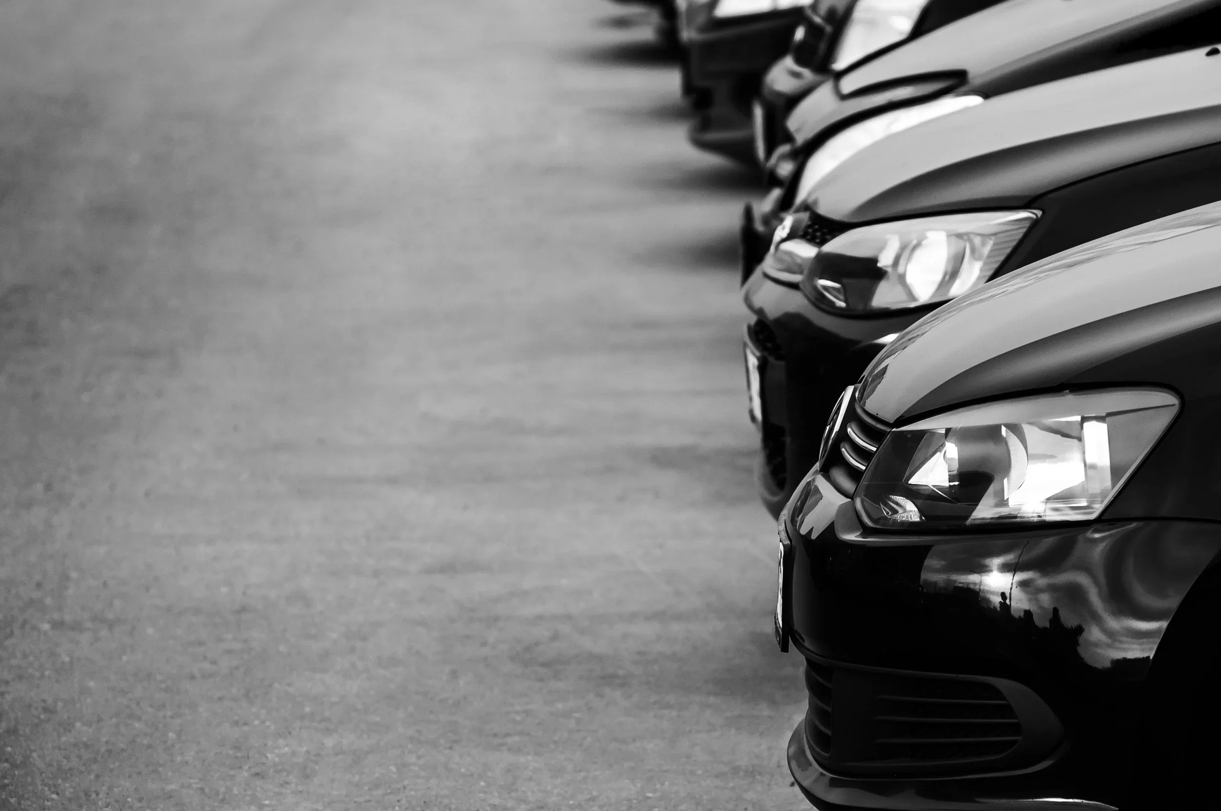 Fila de vehículos corporativos alineados en un estacionamiento para el control de flotillas de autos de empresas.