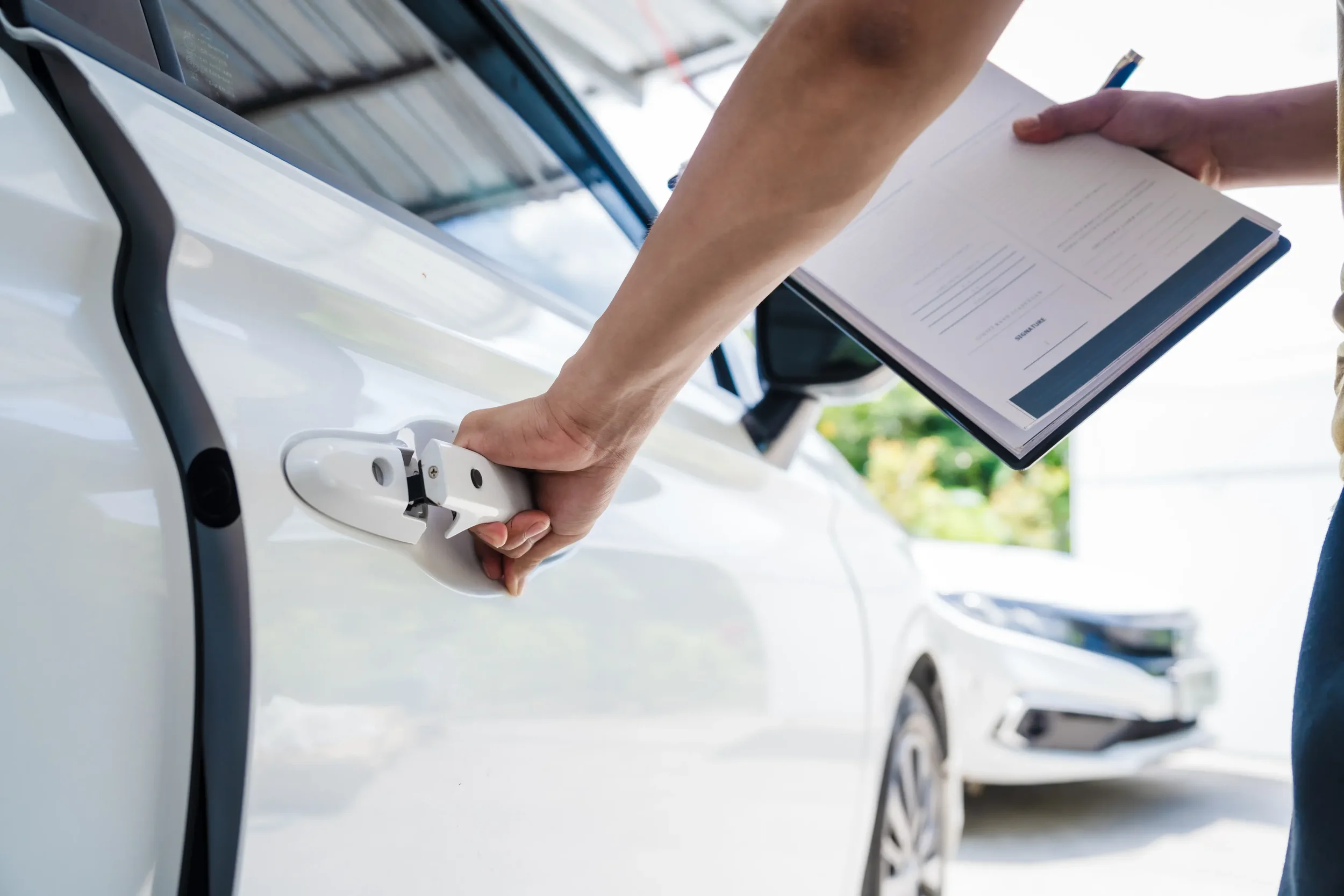 Persona sujeta una carpeta con formularios para realizar el cambio de propietario auto tras una inspección física.