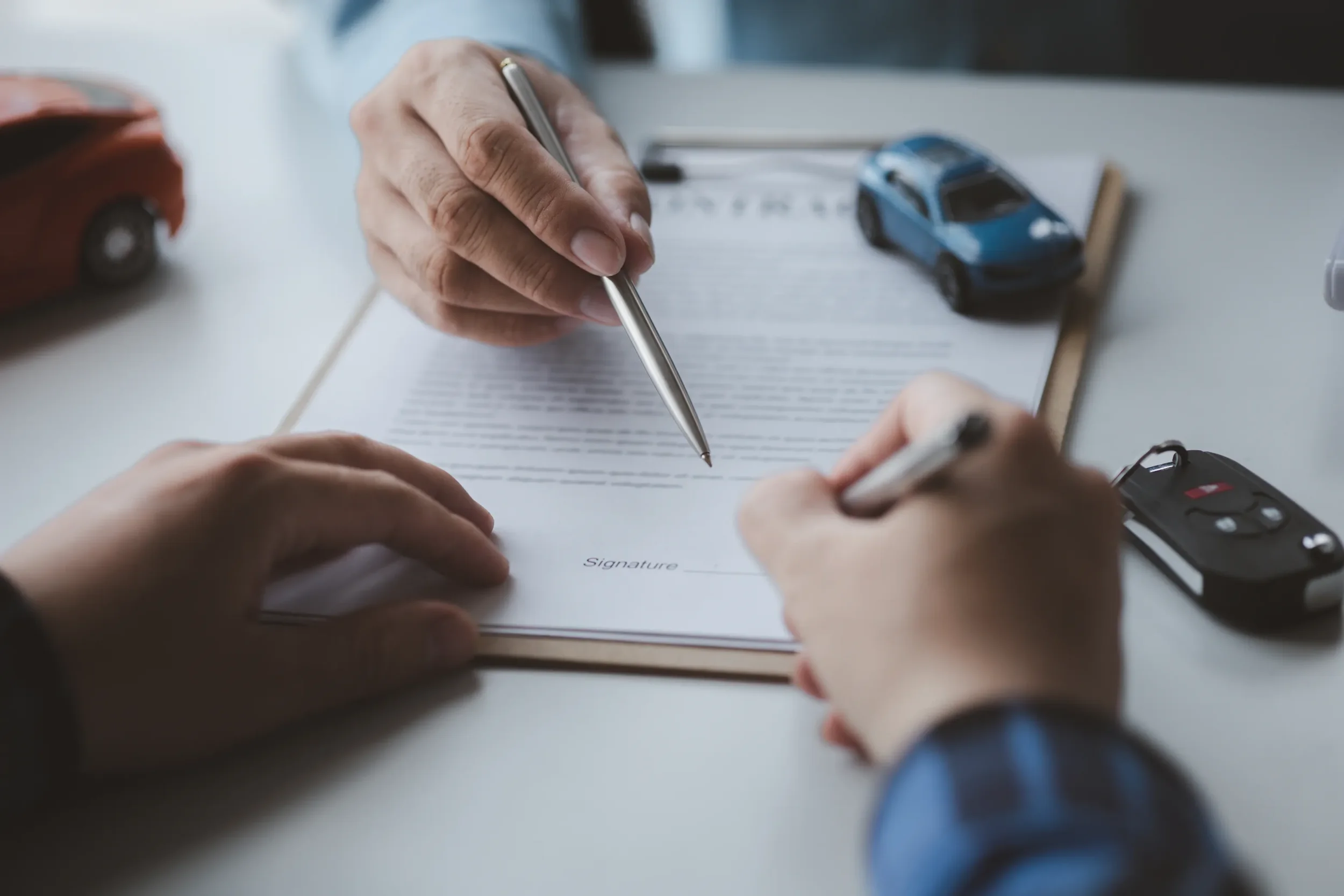 Firma de contrato oficial en oficina para formalizar el proceso de cambio de propietario auto de forma legal y segura.