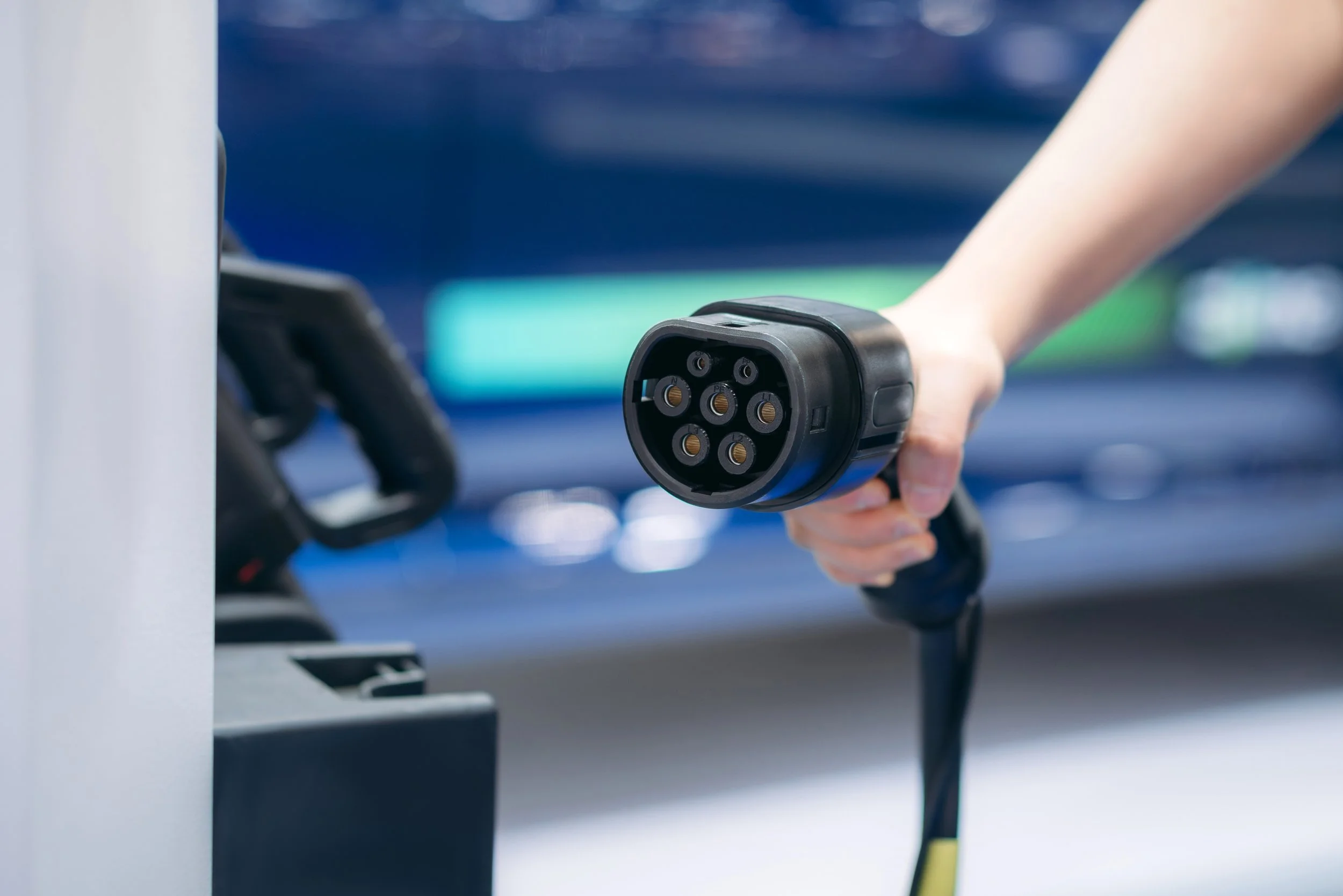 Estación de carga ev charger instalada al aire libre conectada bajo un cielo azul con nubes durante un día soleado.