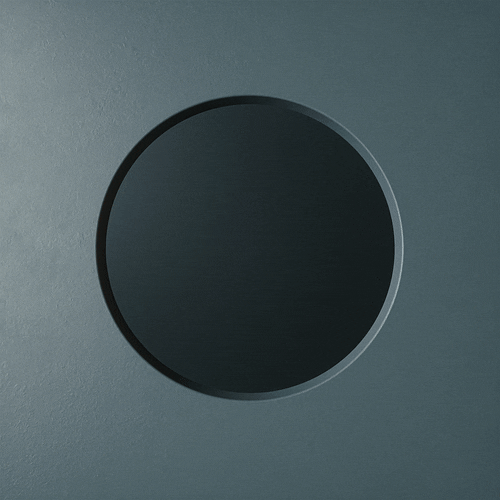 Close-up of a round black button or knob on a gray surface.