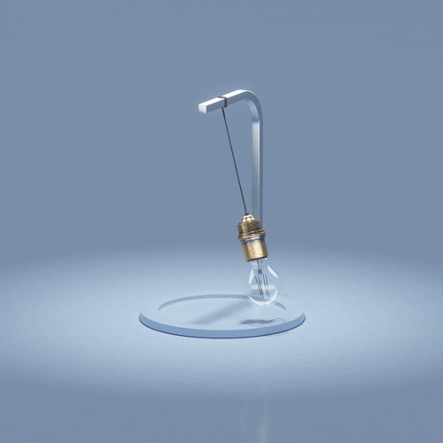 A light bulb hanging from a metal probe, with a clear round base on a plain surface.