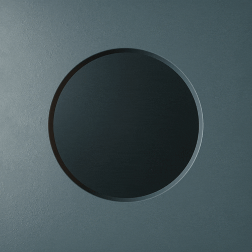 Close-up of a round, black button or knob on a gray surface.