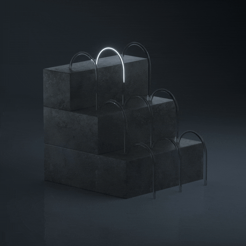 Three-tiered black block display with silver arch handles, illuminated by a single white light.