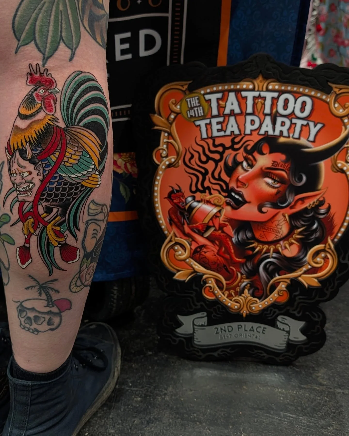 Tattooed leg with colourful traditional Japanese style tattoos, next to an award for 2nd place Best Oriental Tattoos at Tattoo Tea Party.