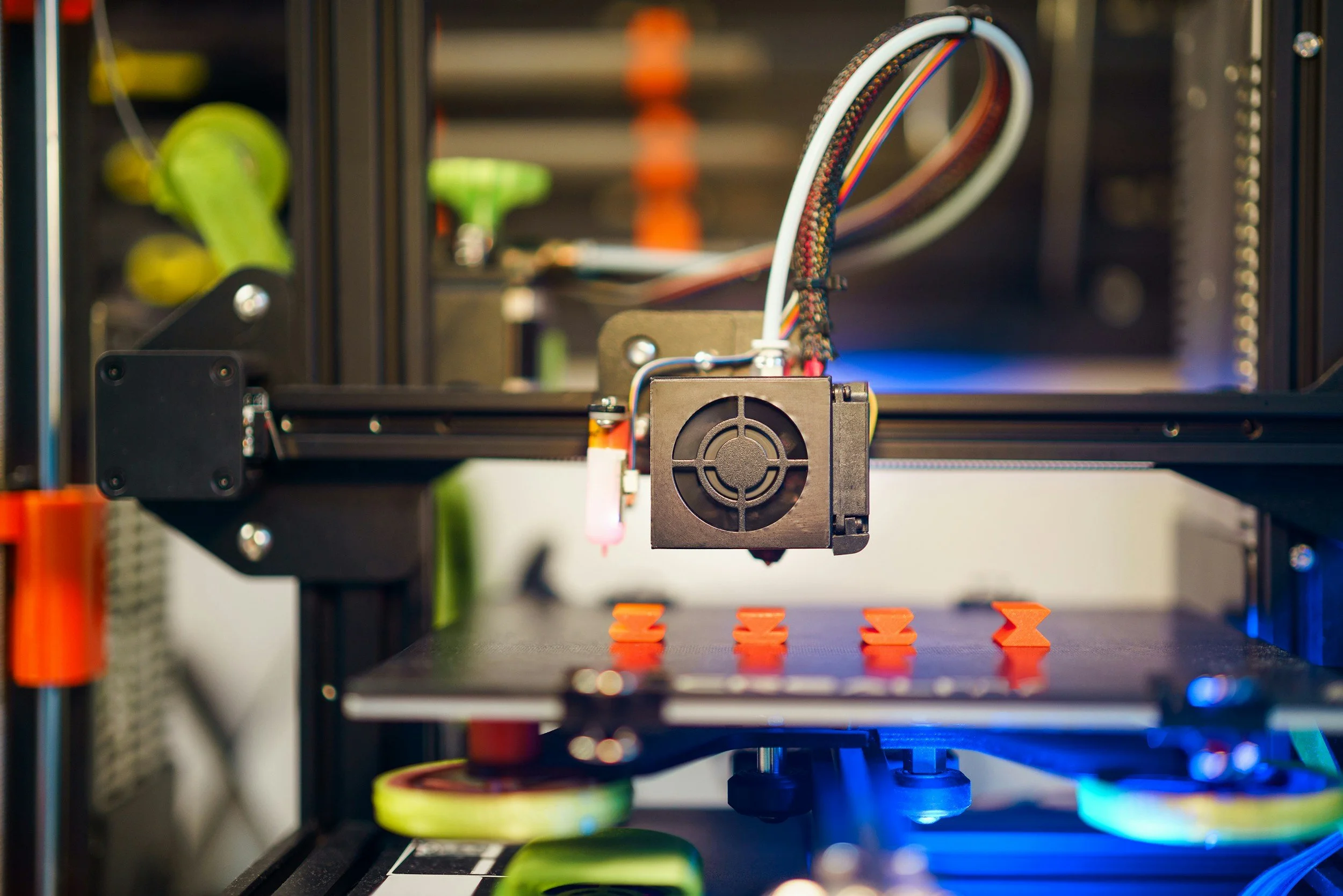 3D printer fabricating an orange object