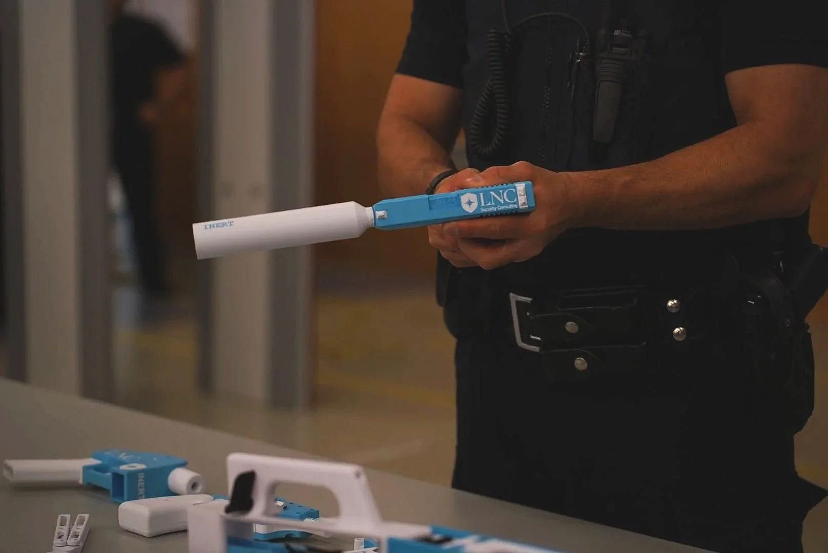 Security guard holding one of LNC's inert ghost guns for training purposes