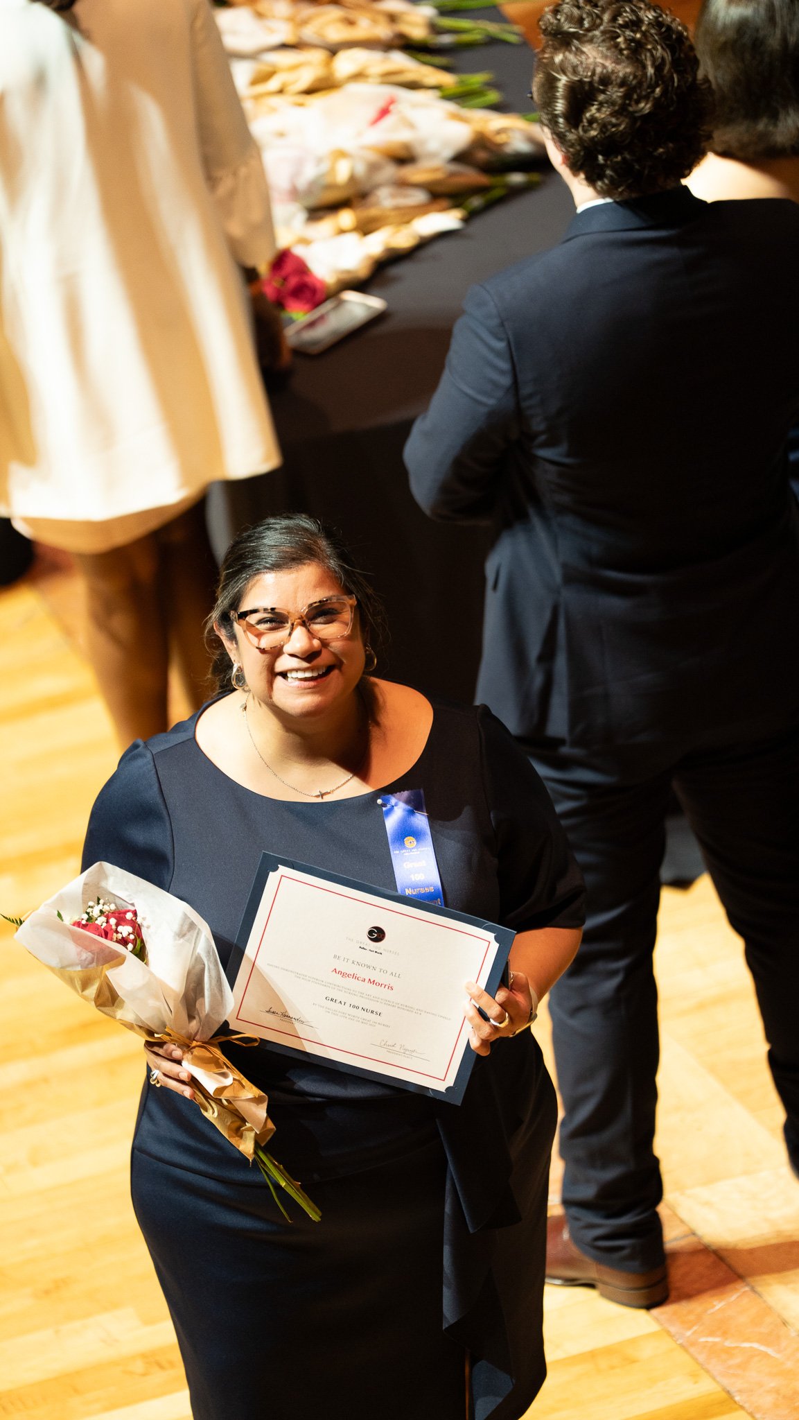 This honoree after receiving her certificate, flowers, and pin—each one a symbol of the impact she’s made. In that moment, the room celebrated not just her accomplishments, but the heart and dedication behind them.