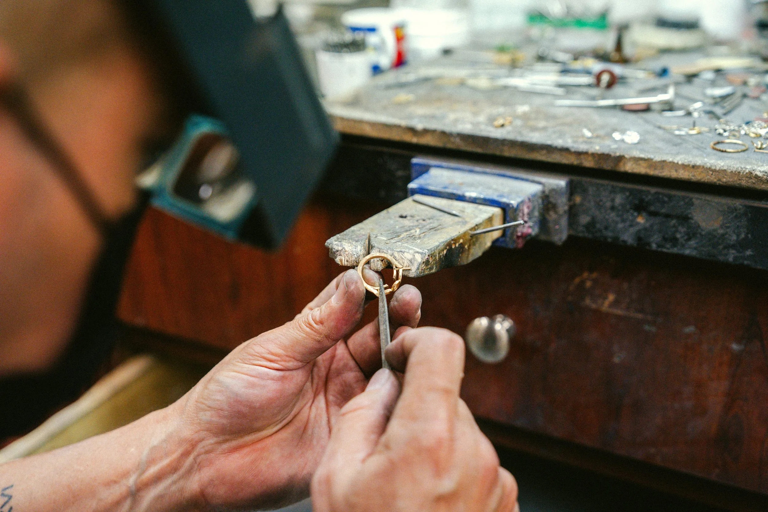 Jeweler working on a custom gold ring in the workshop