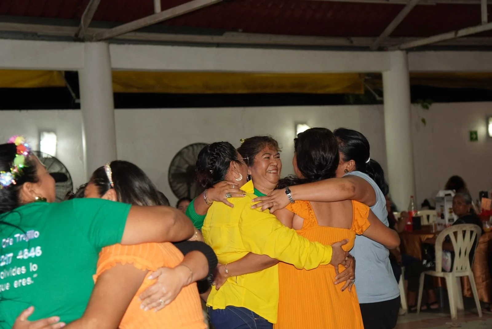 Grupo de mujeres abrazándose y sonriendo en una reunión social.