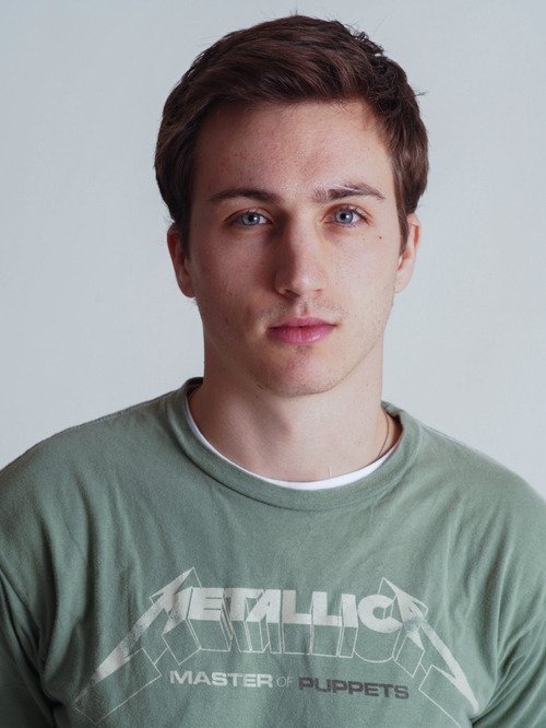 A young man wearing a green "Metallica Master of Puppets" T-shirt, standing against a plain background.