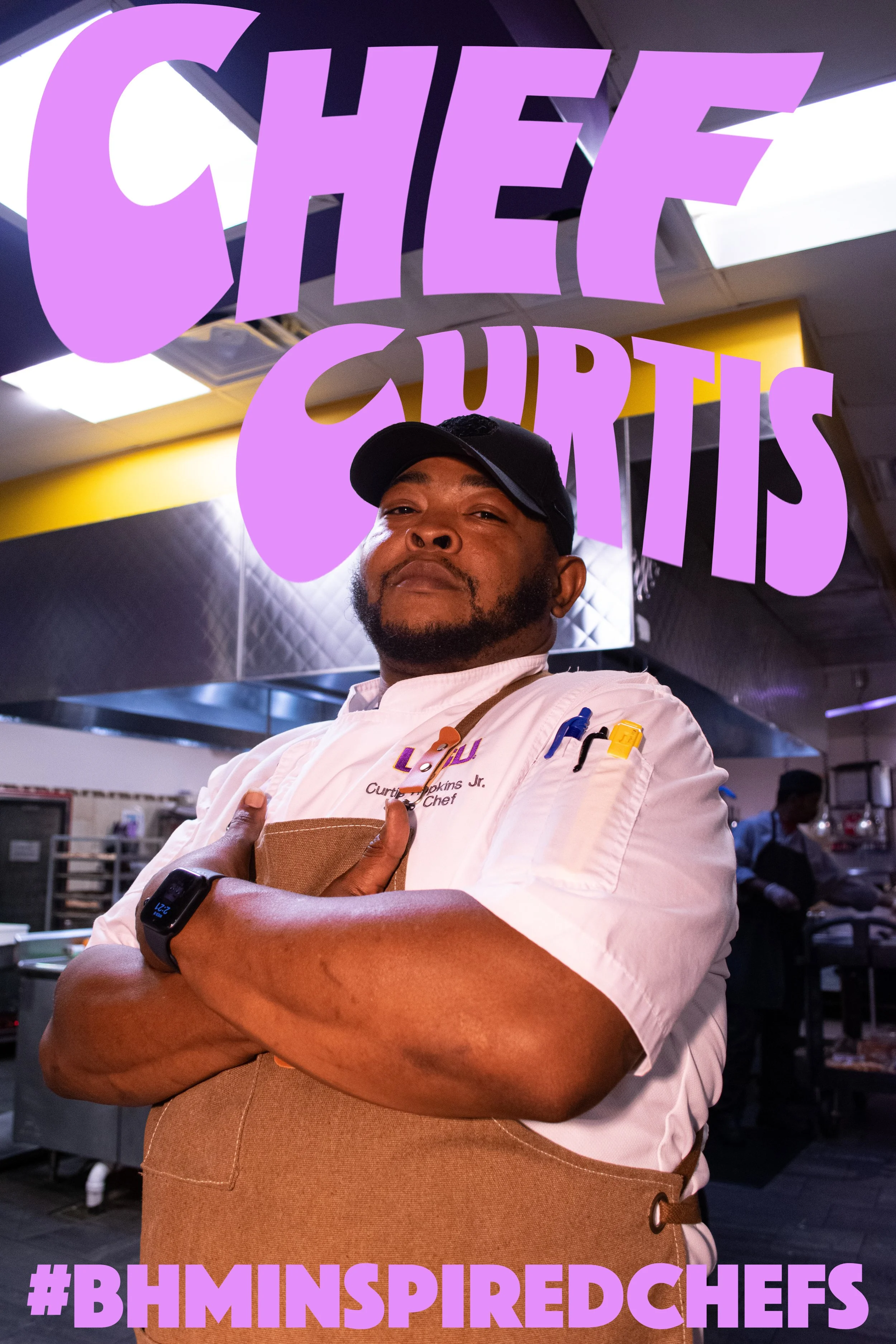 Chef Curtis standing confidently in a commercial kitchen, wearing a chef's uniform and apron, with arms crossed. Hashtag #BHMInspiredChefs is displayed.