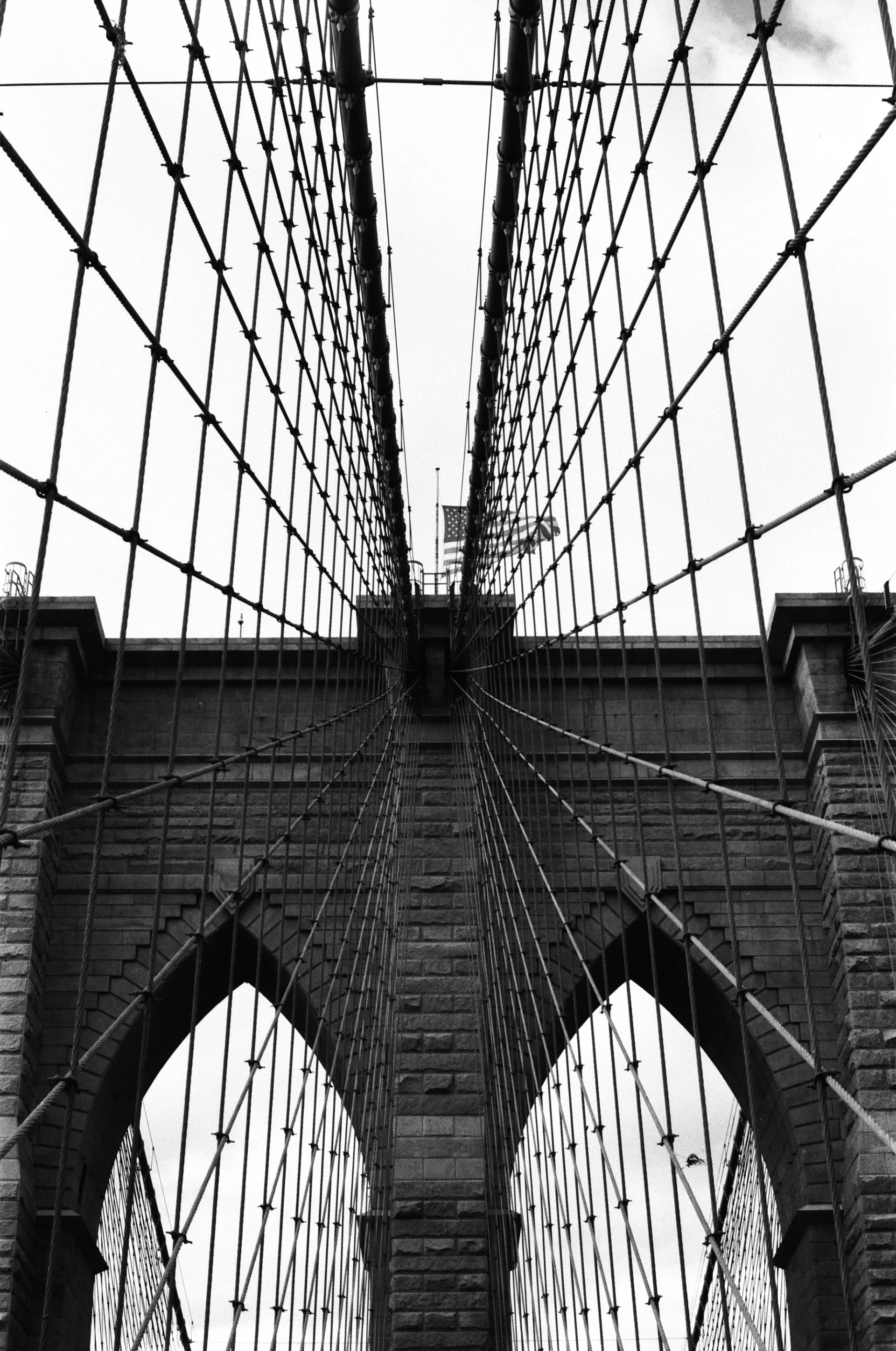 View from beneath the Brooklyn Bridge, showing cables and stone arches