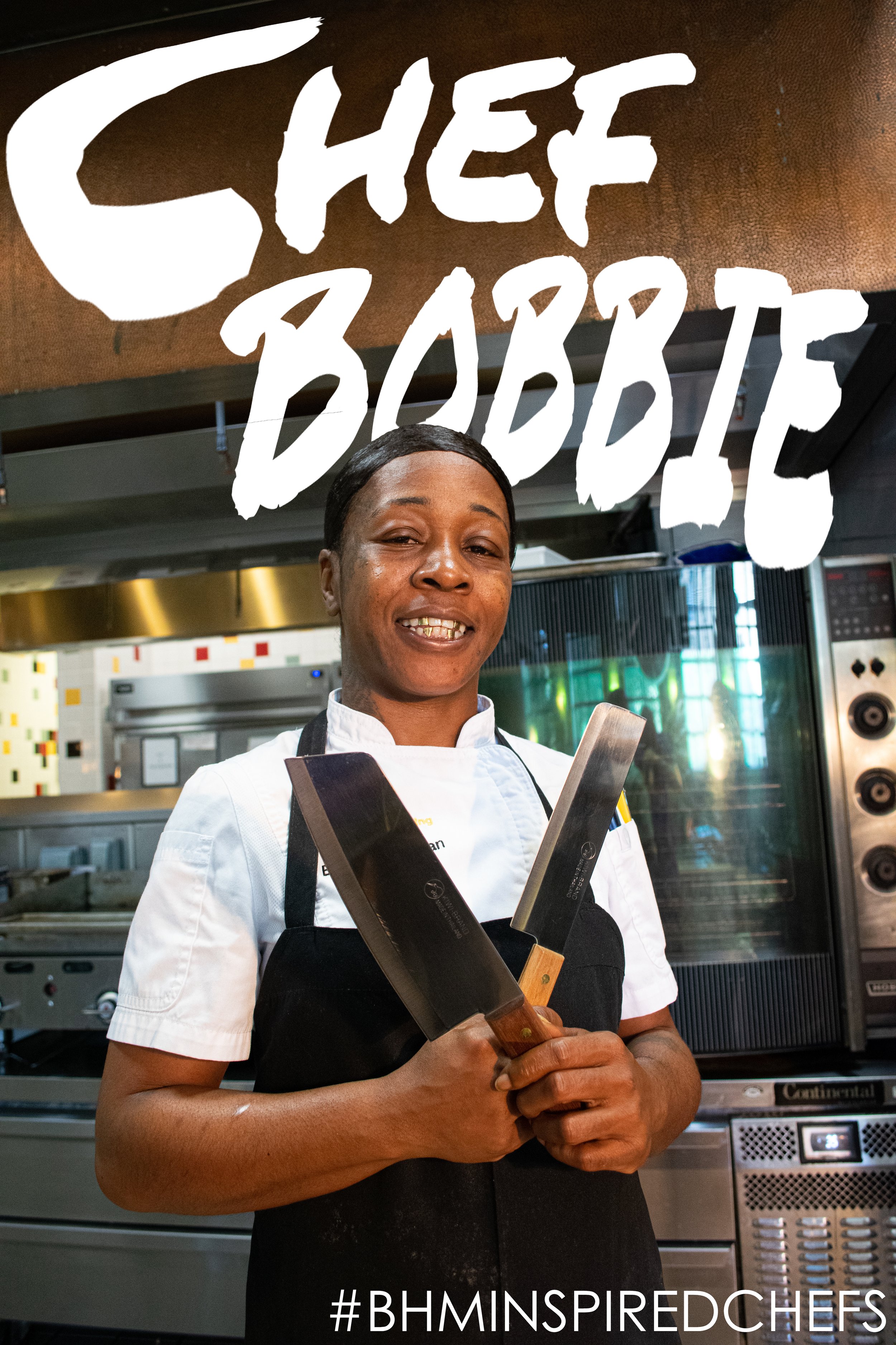 Chef in a commercial kitchen holding two large kitchen knives, with the text "Chef Bobbie" above and "#BHMINspiredChefs" below.