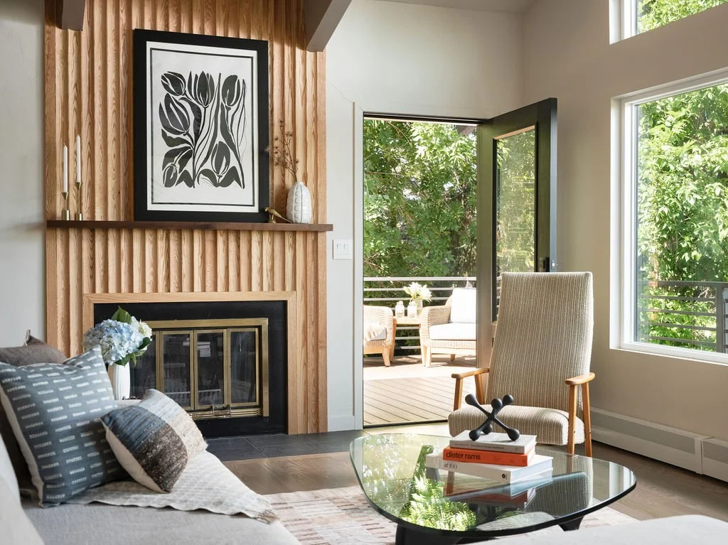 Modern Boulder living room with wood fireplace wall, neutral lounge chair, glass coffee table, indoor-outdoor flow, and organic interior design by Z. Tay Interiors.