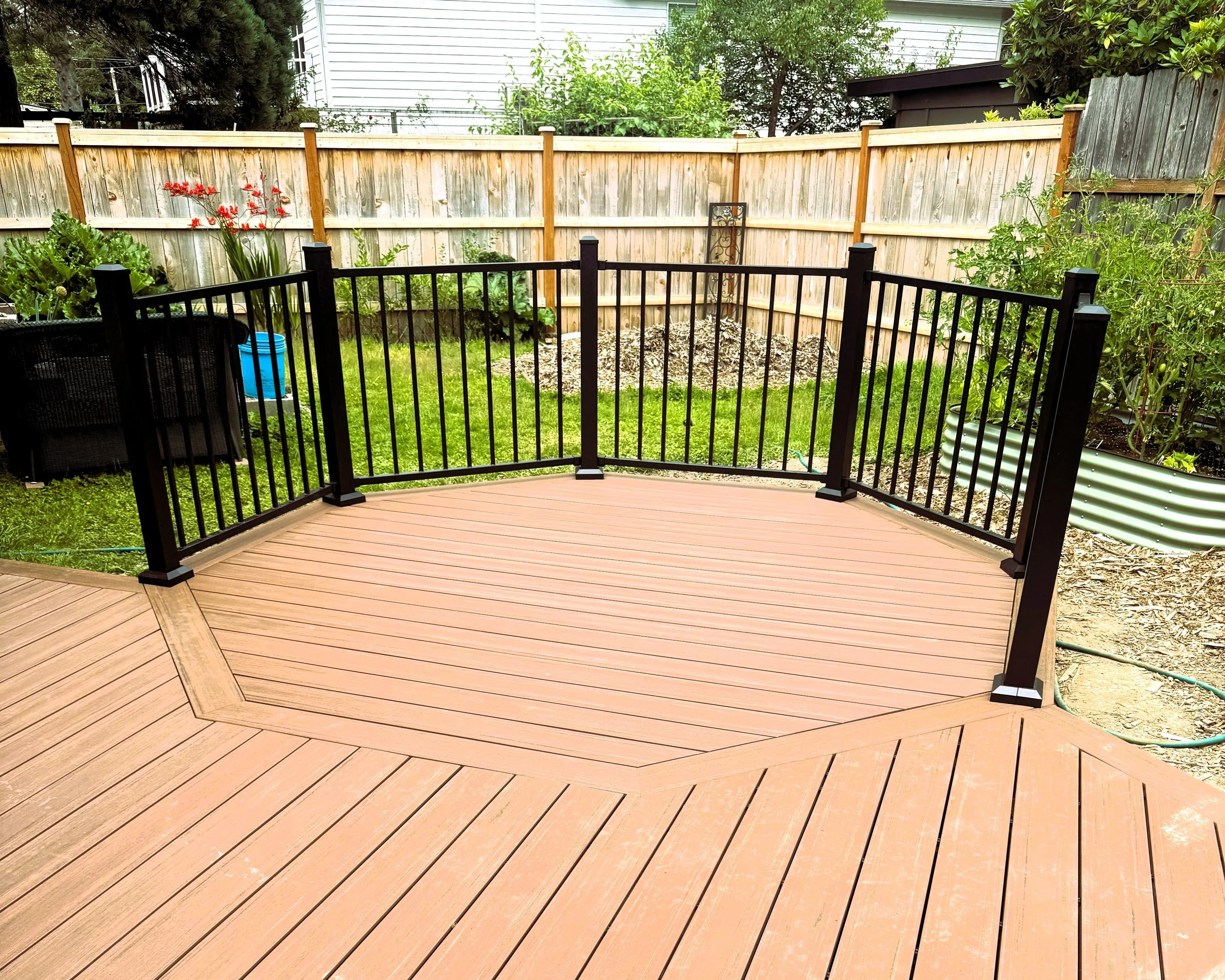 Black aluminum picket railing surrounding a low-maintenance composite deck