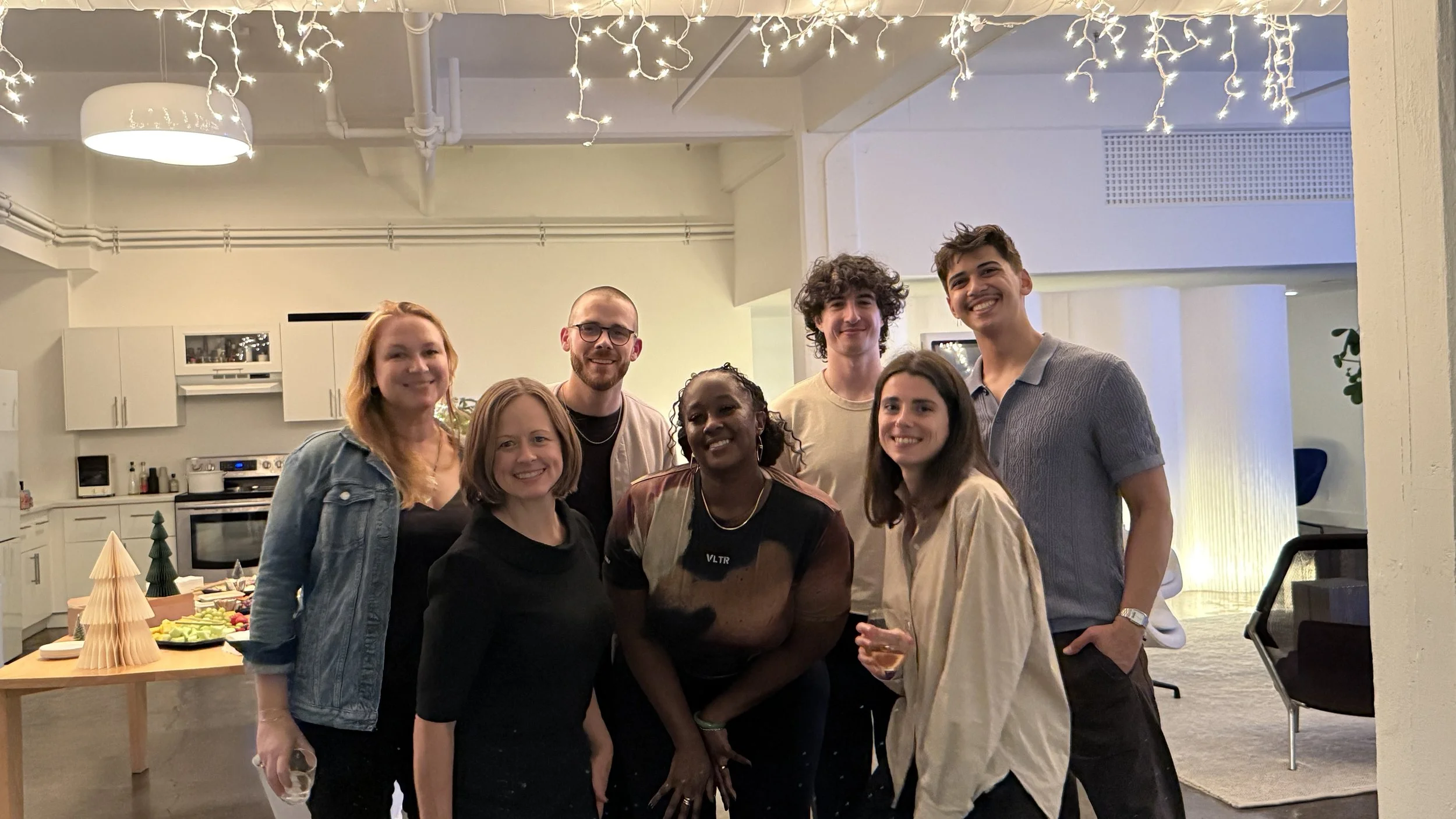 Team photo showcasing seven people during a holiday celebration.