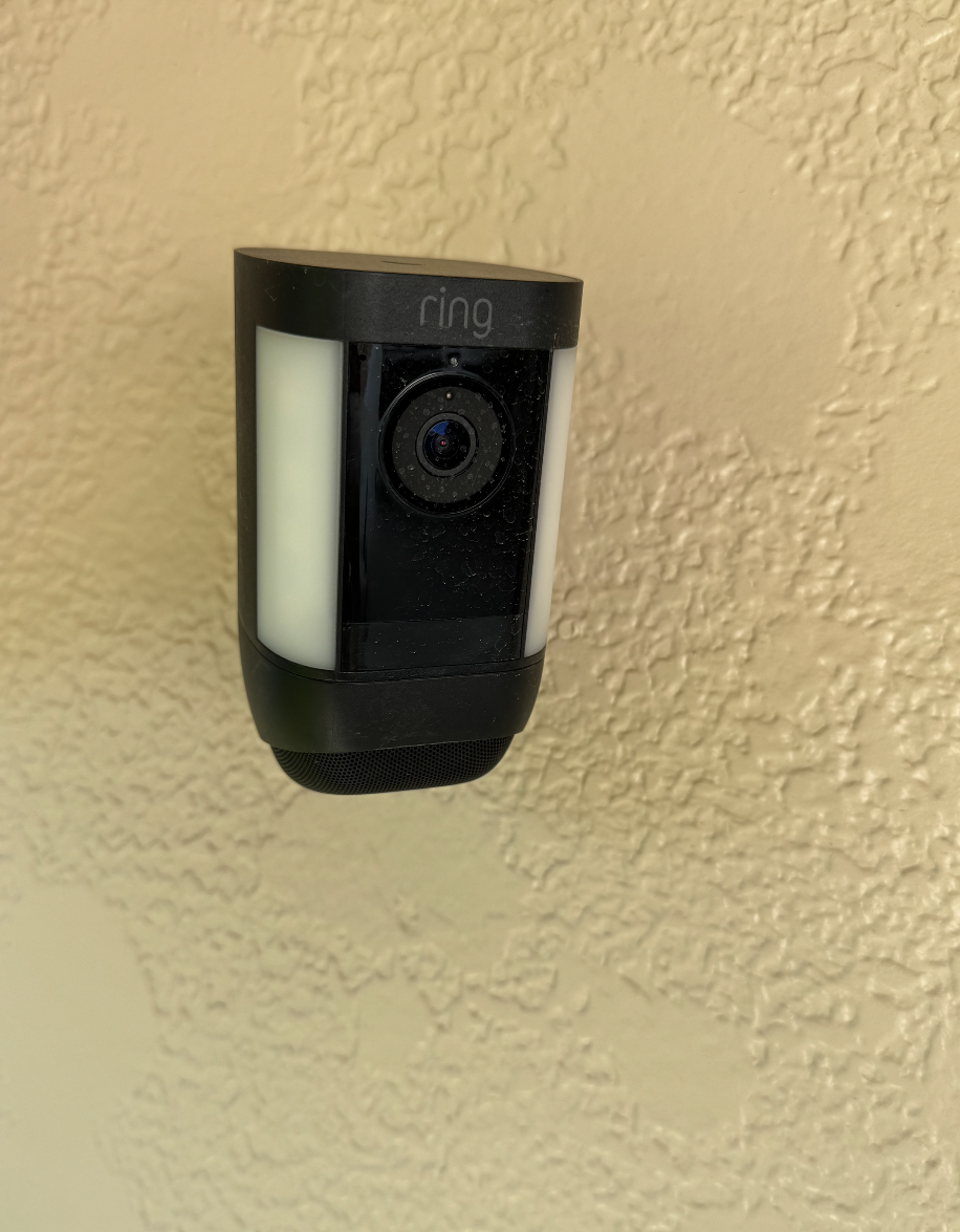 Ring security camera mounted on a textured beige wall.