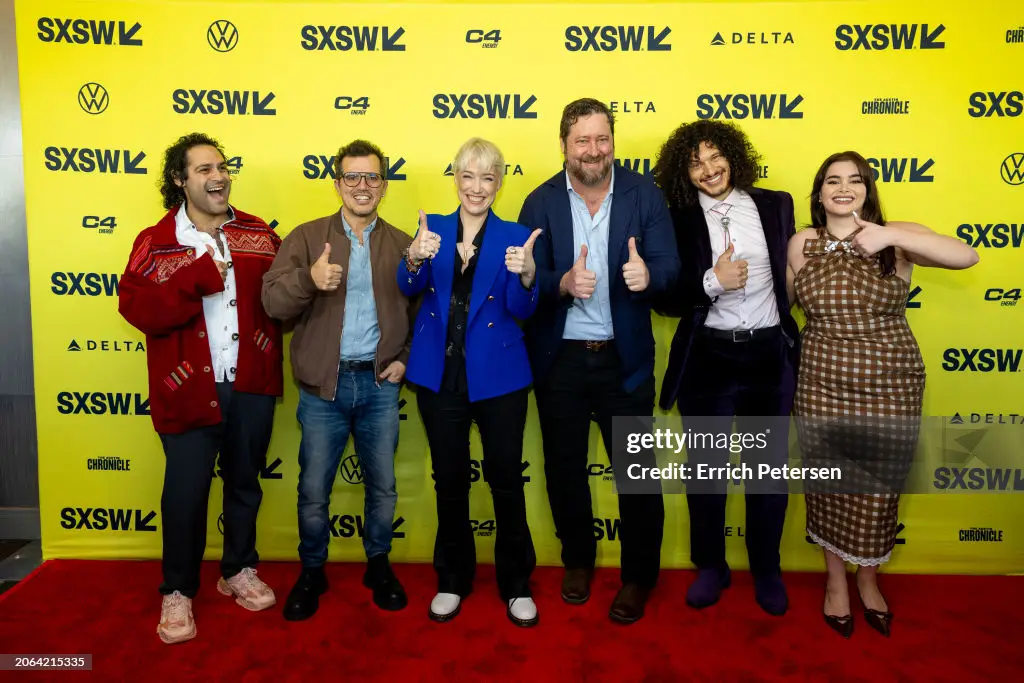 Five By Eight Productions standing in front of a yellow SXSW backdrop, giving thumbs up and smiling.