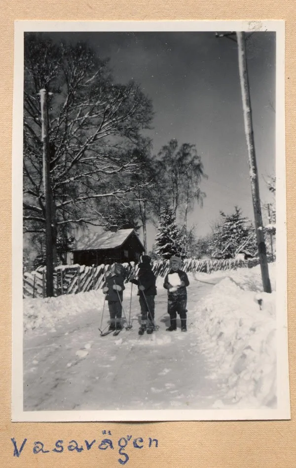  Vinterväg utanför sommarstugan Hasselbacken vid Wasavägen, Djurgården i Lindholmen.  Stugan ägdes av Eric Holmberg med familj.  Barnen, två på skidor fr v Per-Anders Karlsson, Annika Ahlsén och Lars Ståhl med en snökoka i famnen 