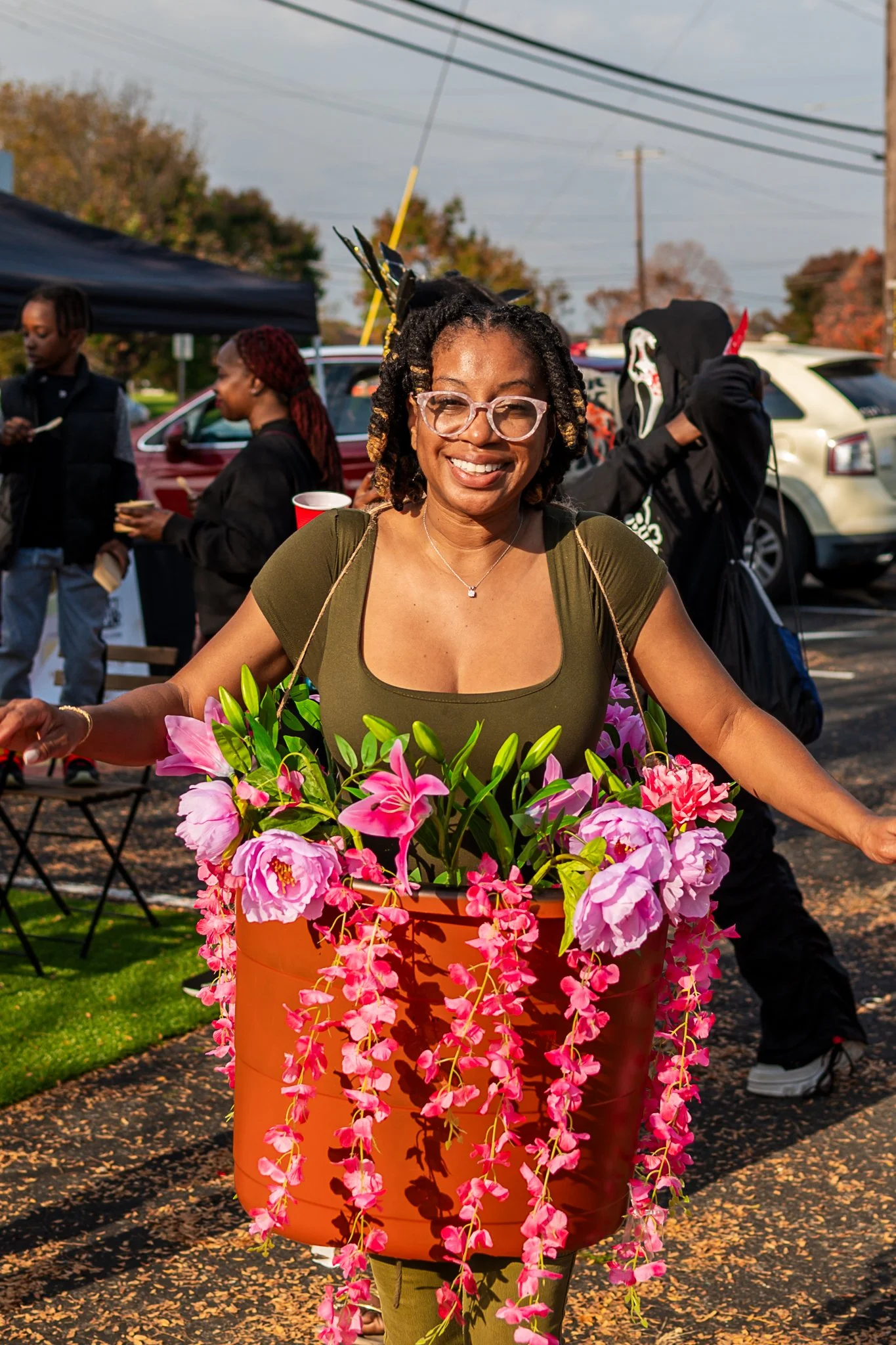photo of young black woman wearing glasses and dressed in a cute and adorable flower pot costume at a farmers market. photo taken by expert event photographer in detroit and se michigan