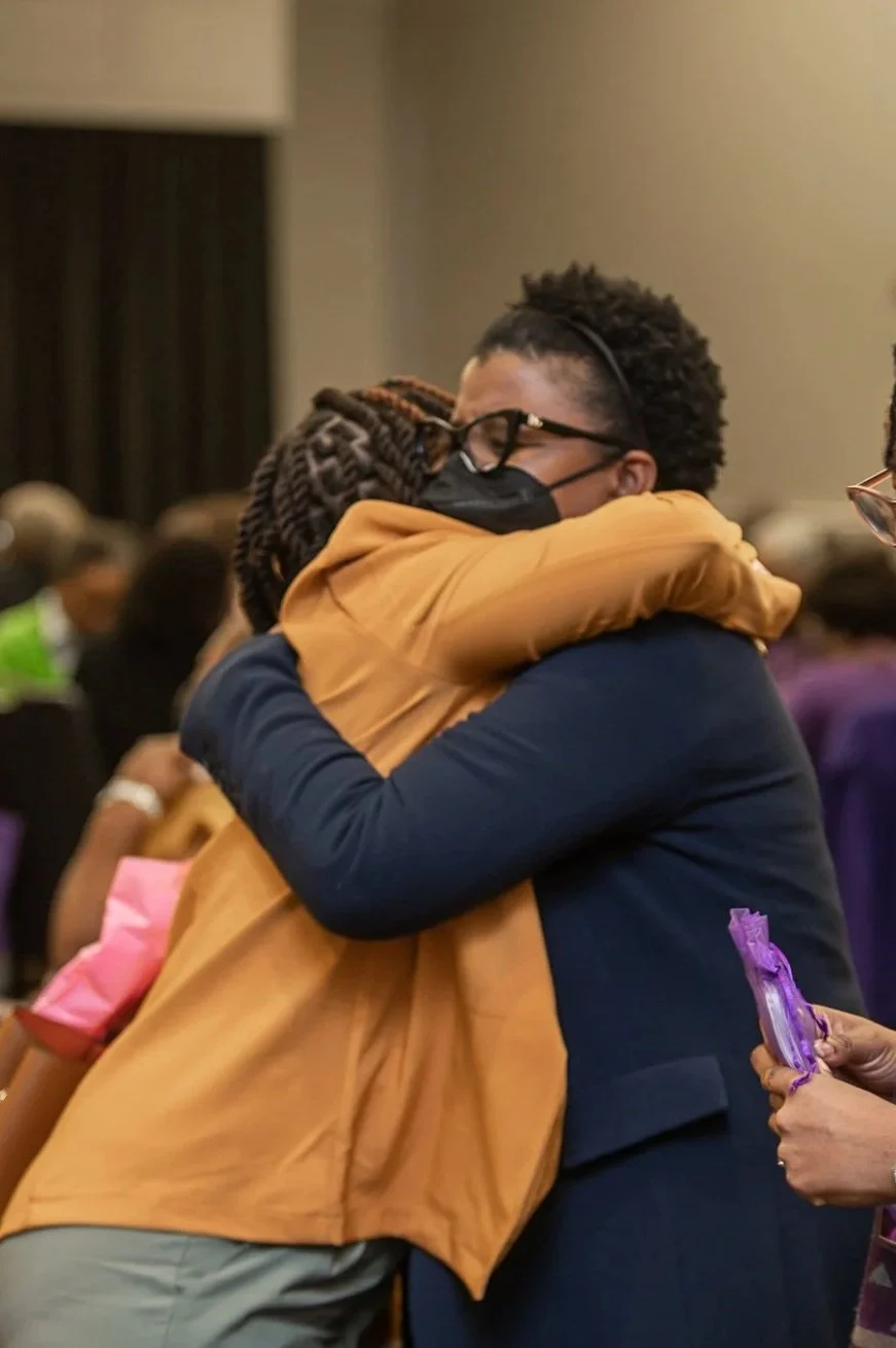 photo of two black women hugging and smiling at a christian women's conference. photo taken by expert event photographer in detroit and se michigan