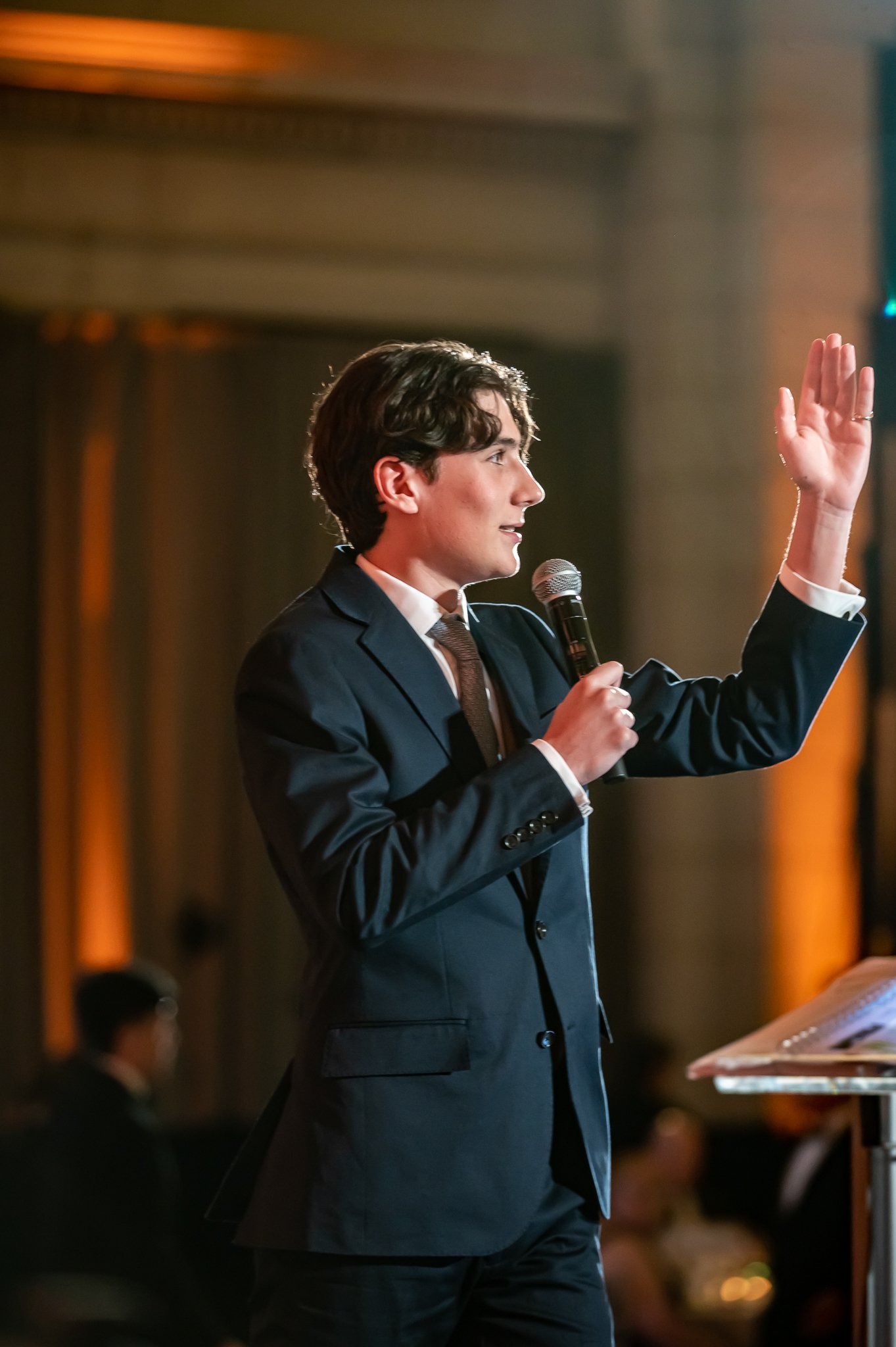 color photo of young white man auctioneering a charity event. photo taken by metro detroit event photographer