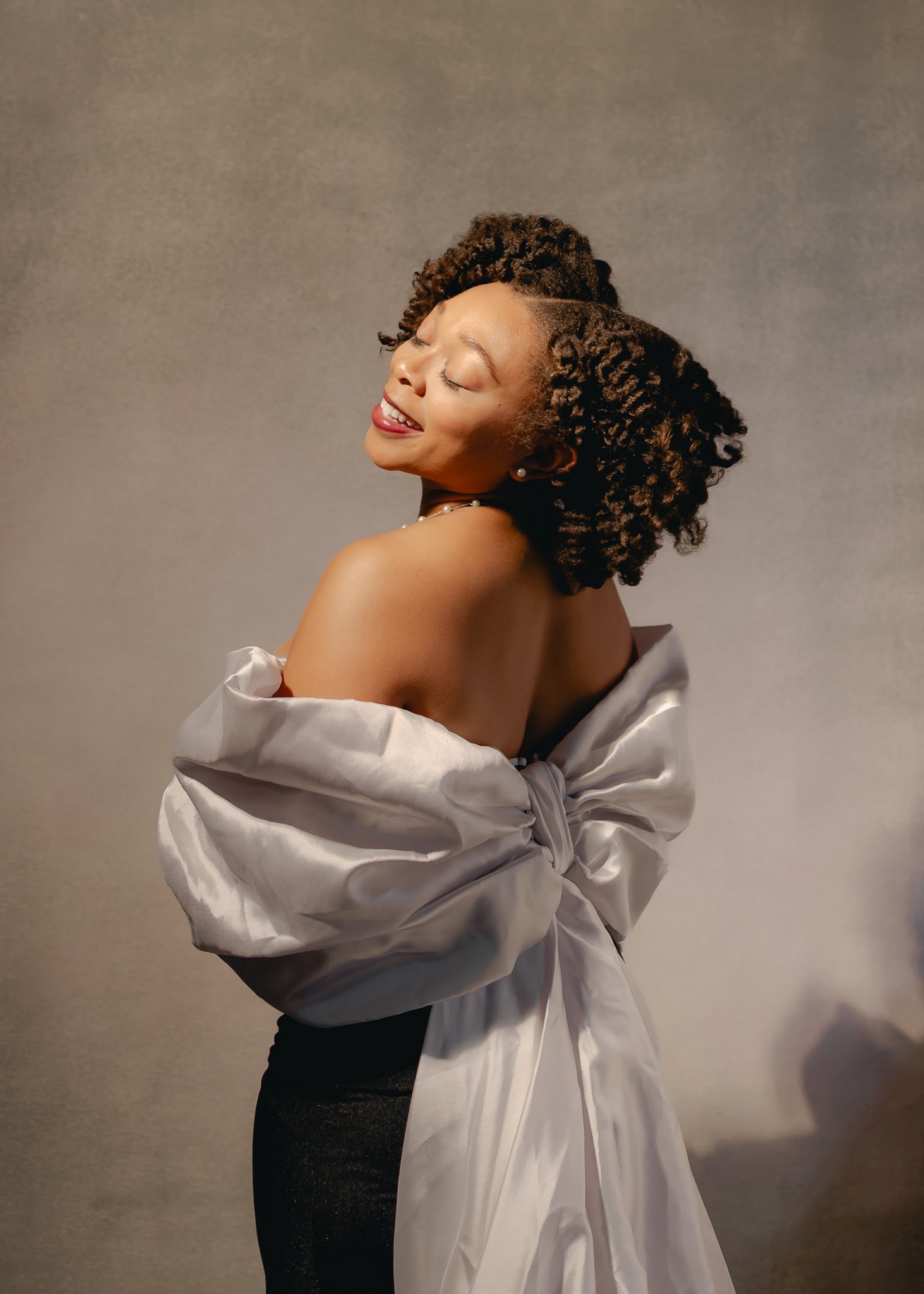 young black woman with curly natural hair posing for vintage style photoshoot. photo was taken by black portrait photographer in pontiac michigan photo studio