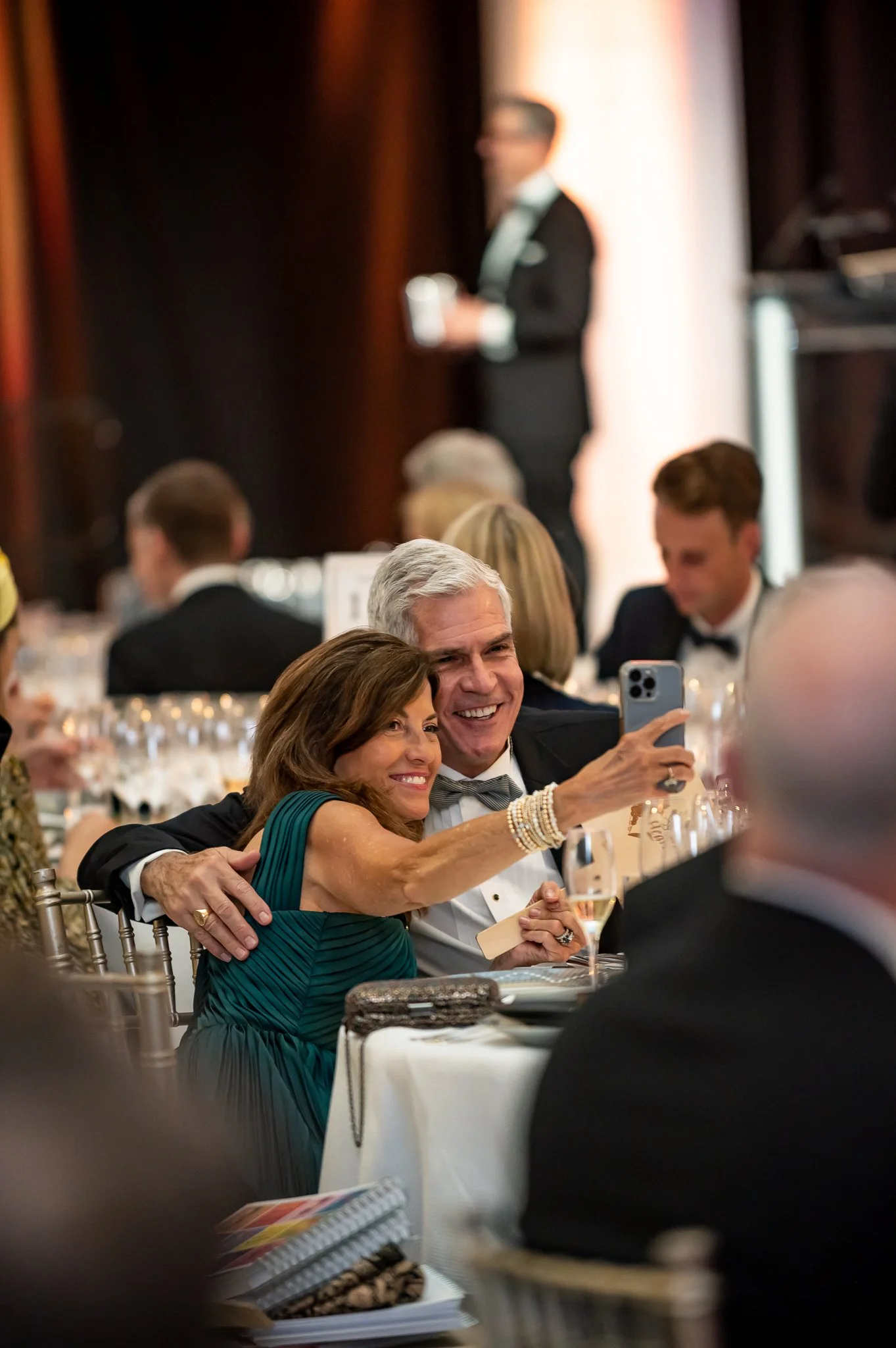 two middle aged white people posing together for a phone selfie at american heart association fundraiser. photo taken by professional event photographer in southeast michigan