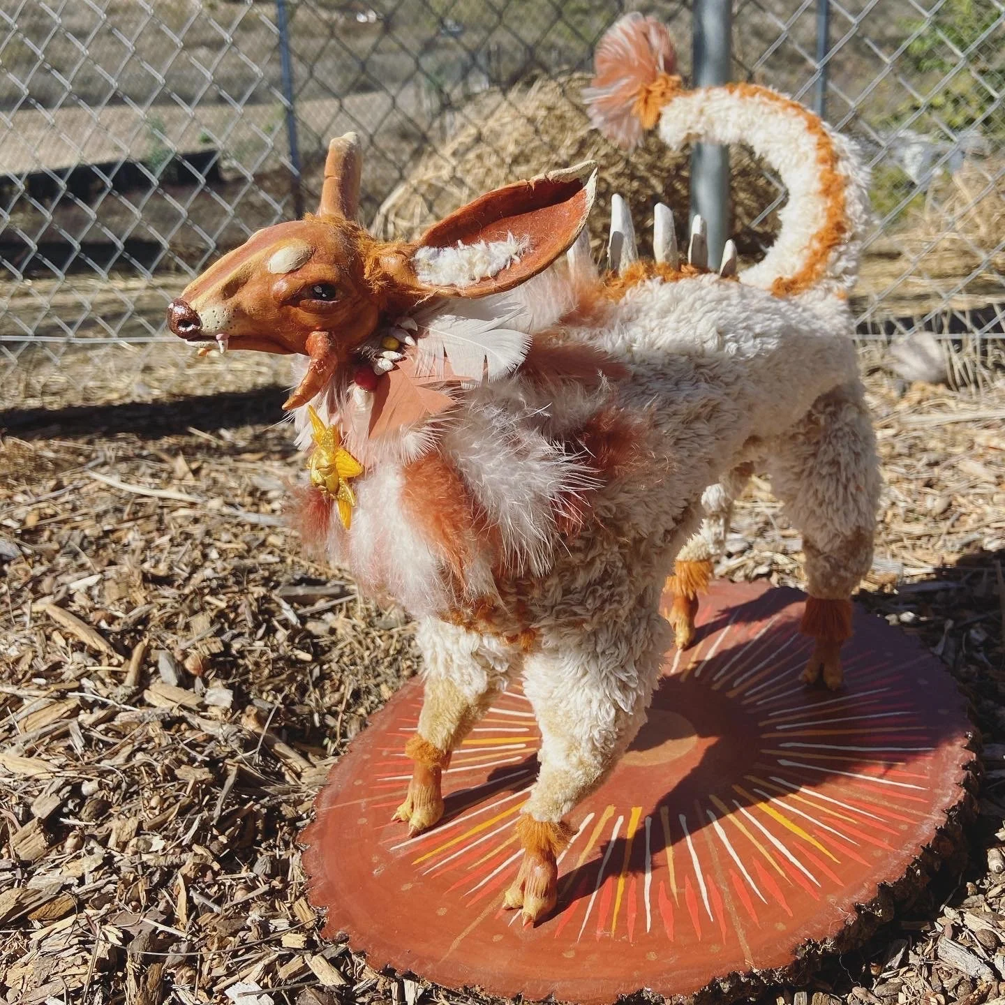 "Sun Guardian" made of recycled blankets, feathers, polymer clay, and handmade clay beads.
