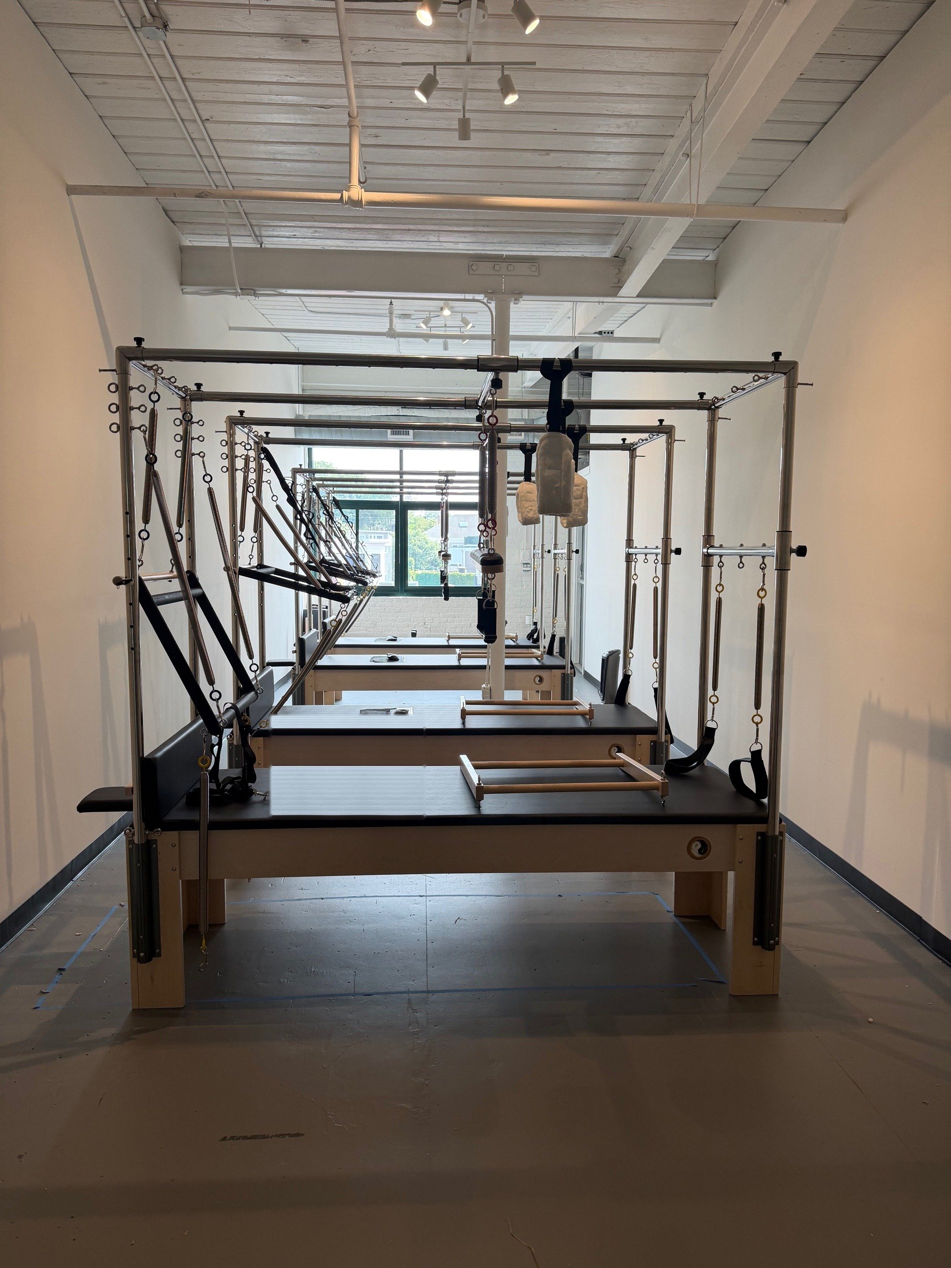 Row of Cadillac Pilates machines at Quin Pilates in Southie.