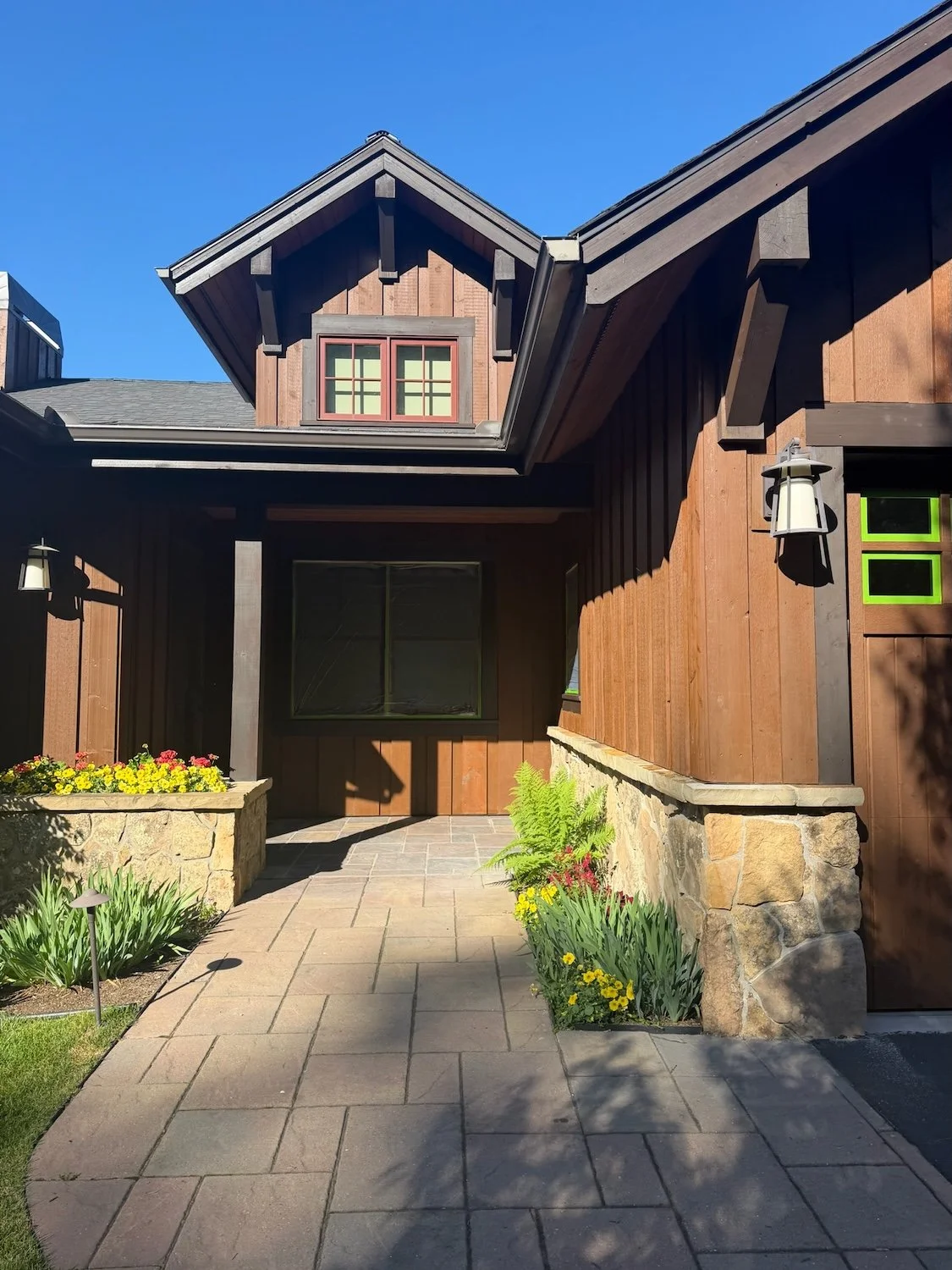 brown log home stained siding with river rock and brick entryway