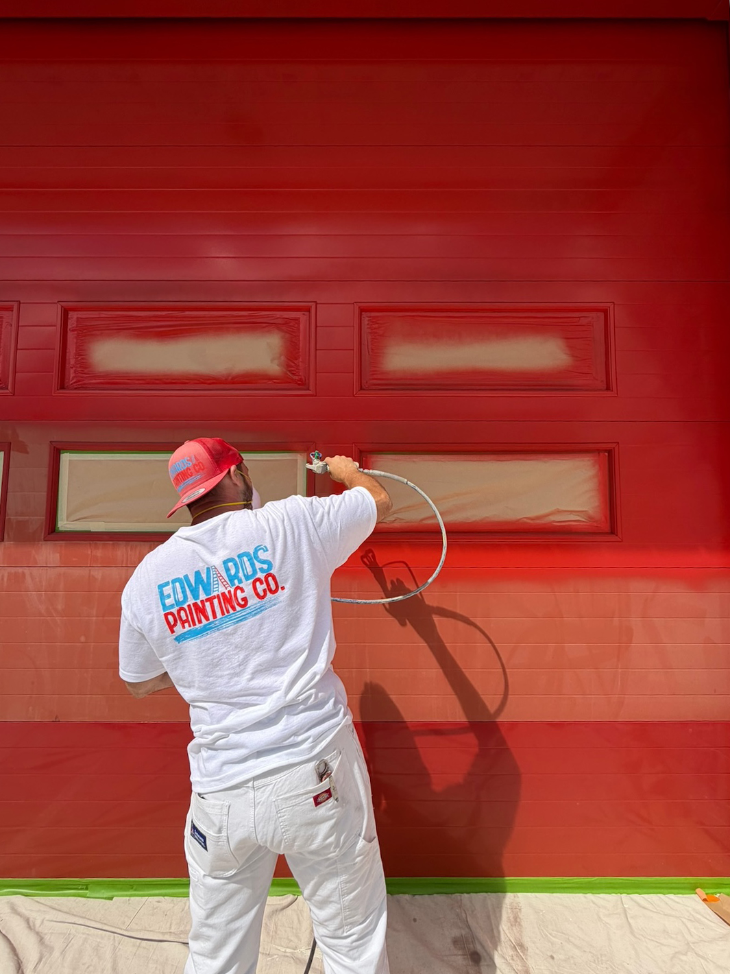Team member paint spraying exterior garage door of Kalispell Fire Department
