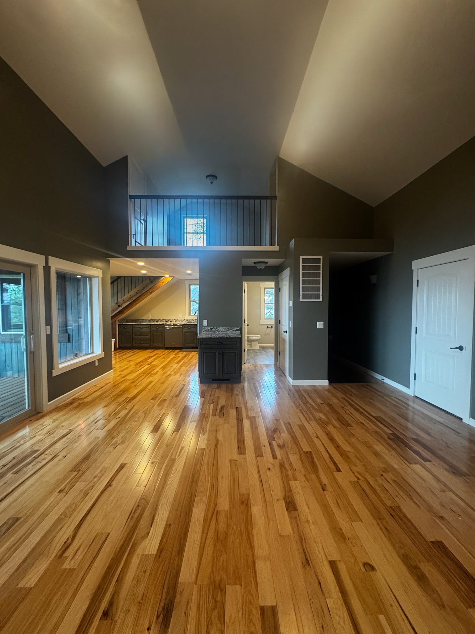 green painted interior living room with vaulted ceilings and loft