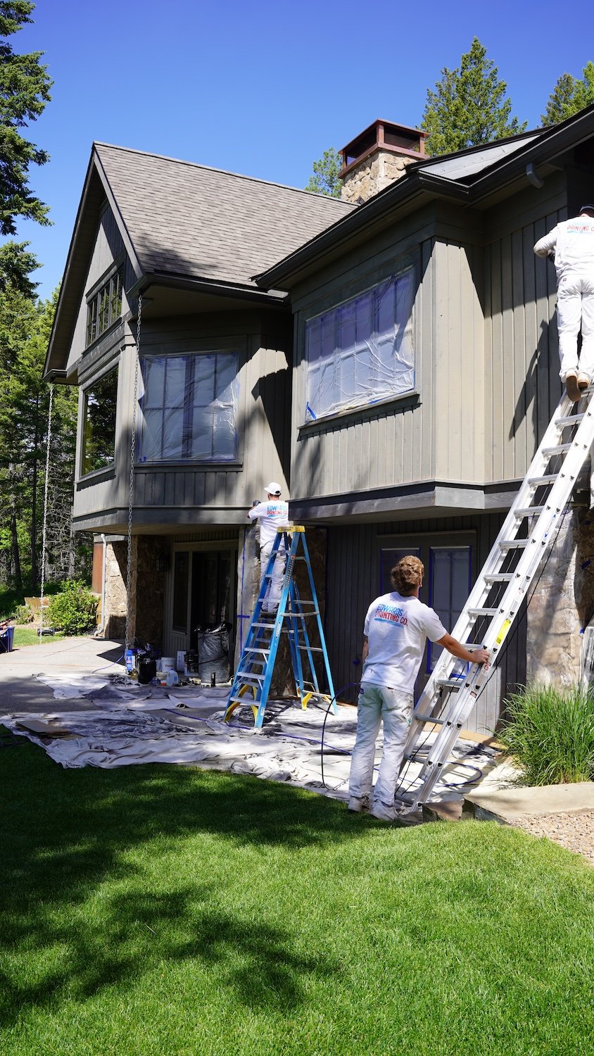 Team member painters painting exterior of home on ladders in Flathead Valley