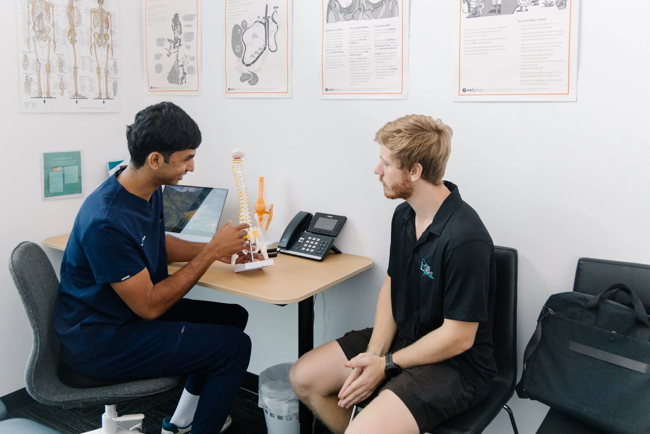Physiotherapist using a spine model to explain pain modulation to a patient at Move Right Physio Dakabin