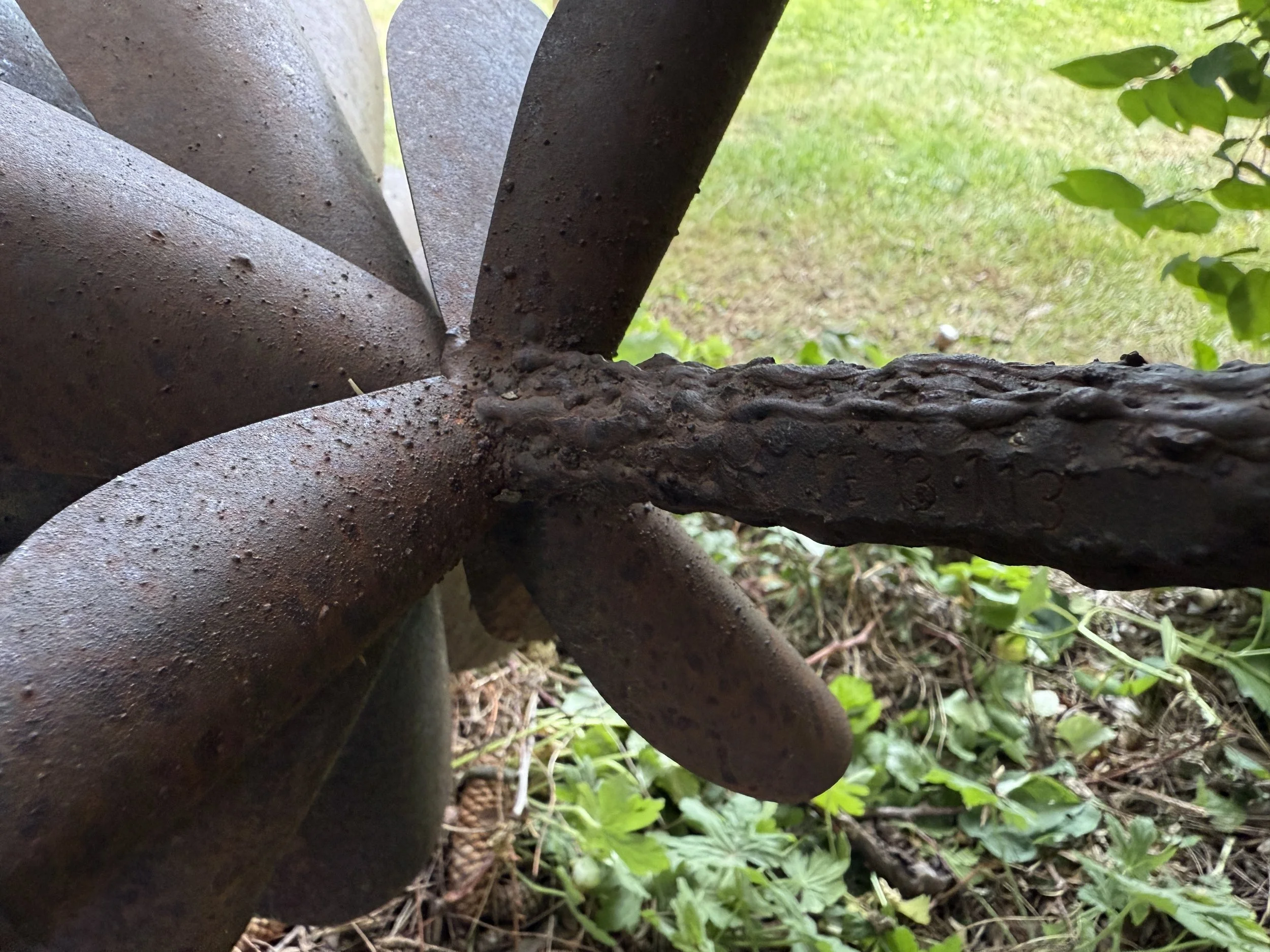 Close up of stamp found on a Floyd Elzinga Metal Pinecone, outdoor sculpture