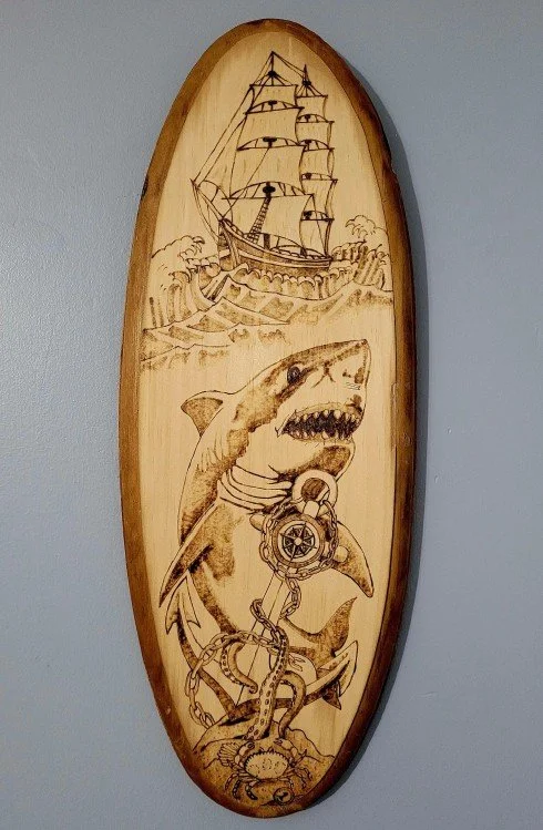 Jadyn Deming.
Dangers Of The Deep, 2026
pyrography on wood
18.5" x 7"
$200