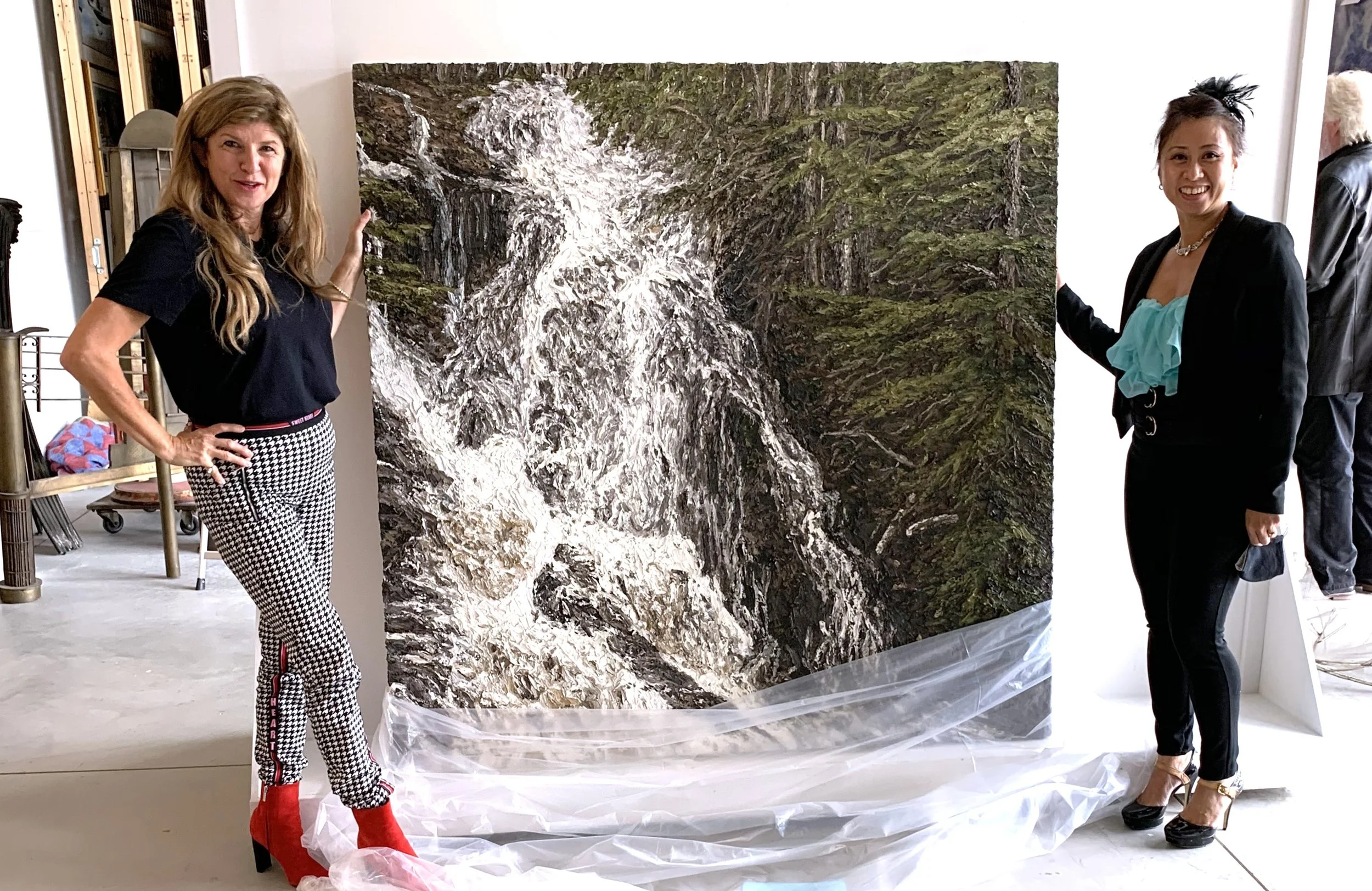 Art Collector Kimberly Campbell poses with curator Margie Galita with a Matt Bahen painting at the John Mann Gallery